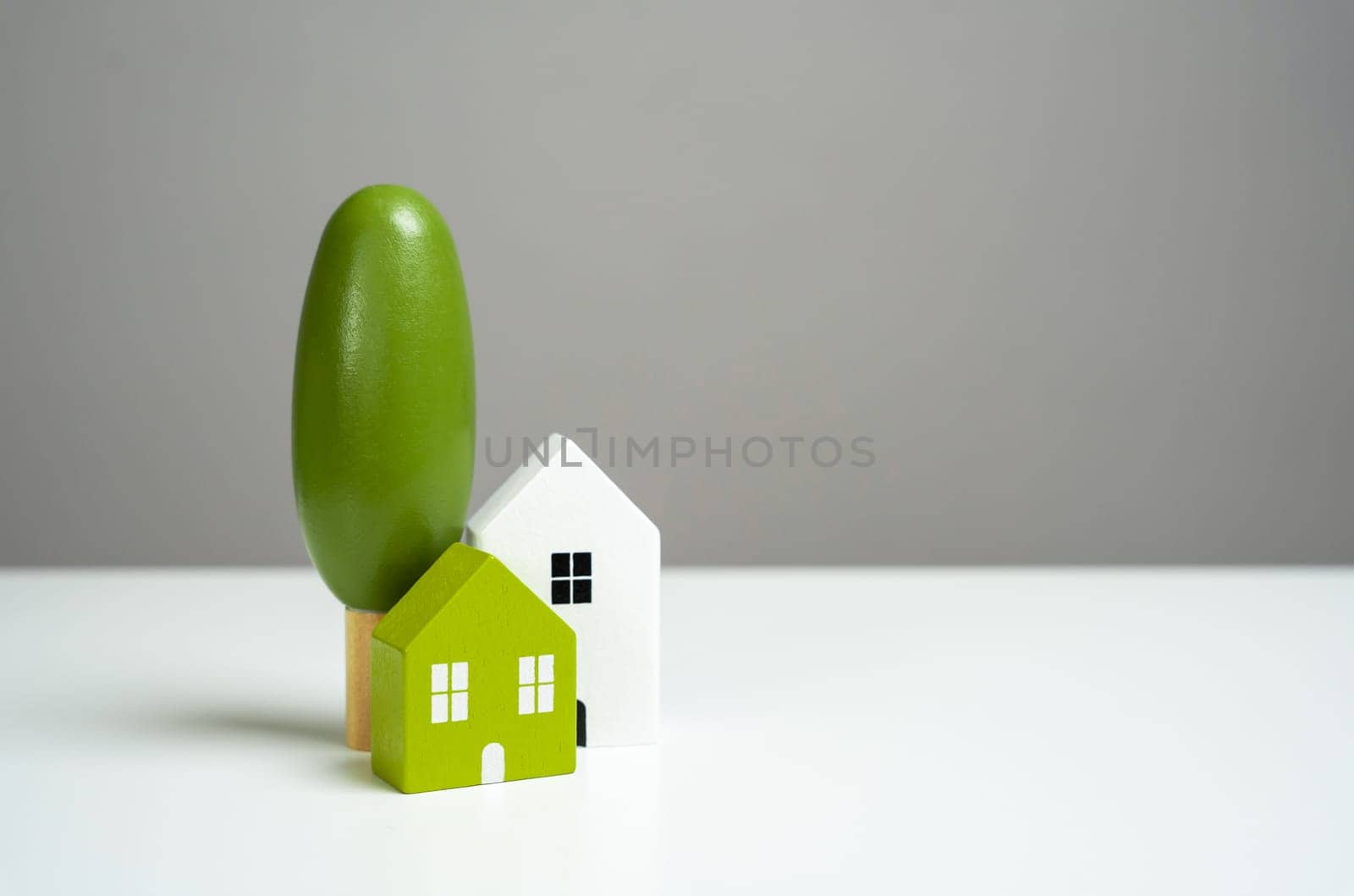 House with trees. Affordable housing. Buying a nice house. Garden work, landscape design. Figurine. Mortgage and loan.