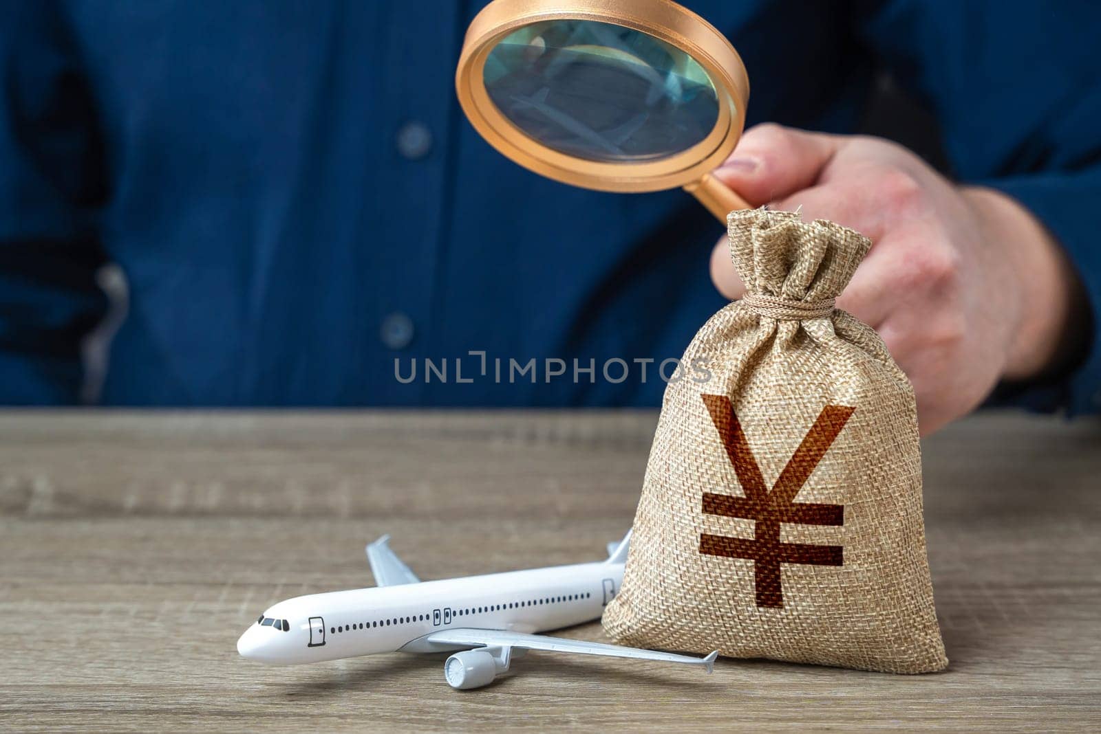 Airplane and chinese yuan or japanese yen money bag under investigation. Economic impact of aviation industry. Payment of taxes, fees and excise taxes. Measure impact on local economy. by iLixe48