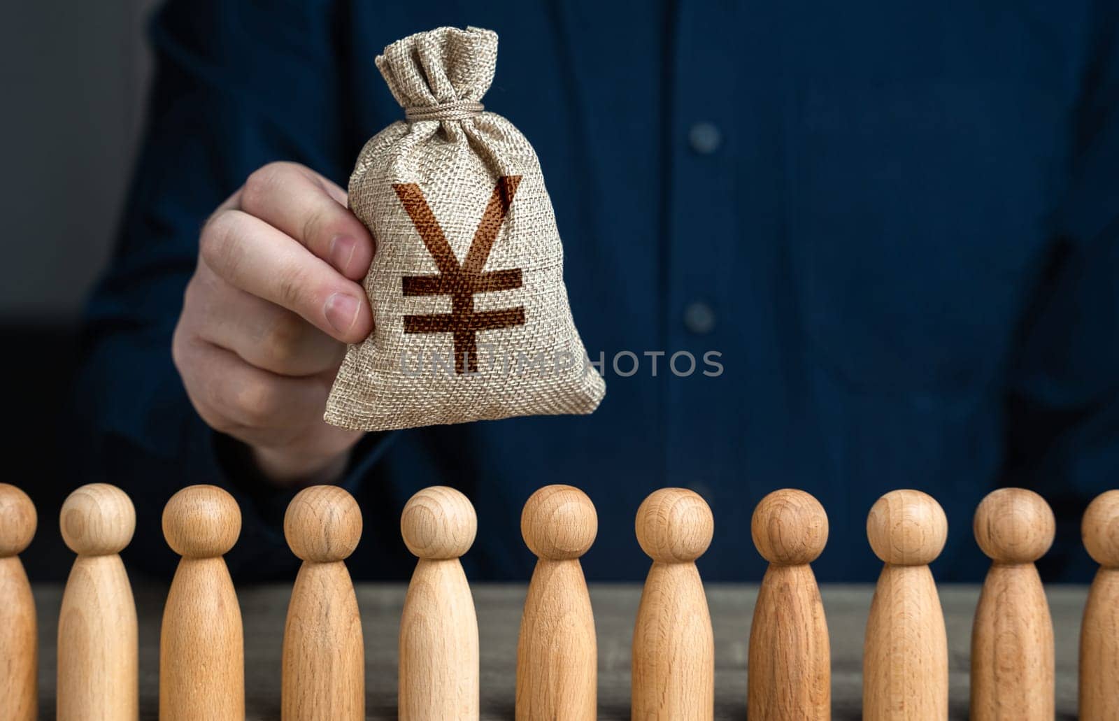 A man holds a chinese yuan or japanese yen money bag above the crowd. Deposits and loans. Budgetary funds for social policy. Social politics. Salaries. Crowdfunding and fundraising.