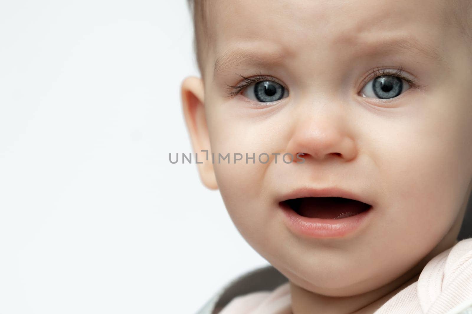 A closeup portrait captures a baby crying due to being tired and hungry, expressing a universal need for comfort. Concept of nurturing and parental care