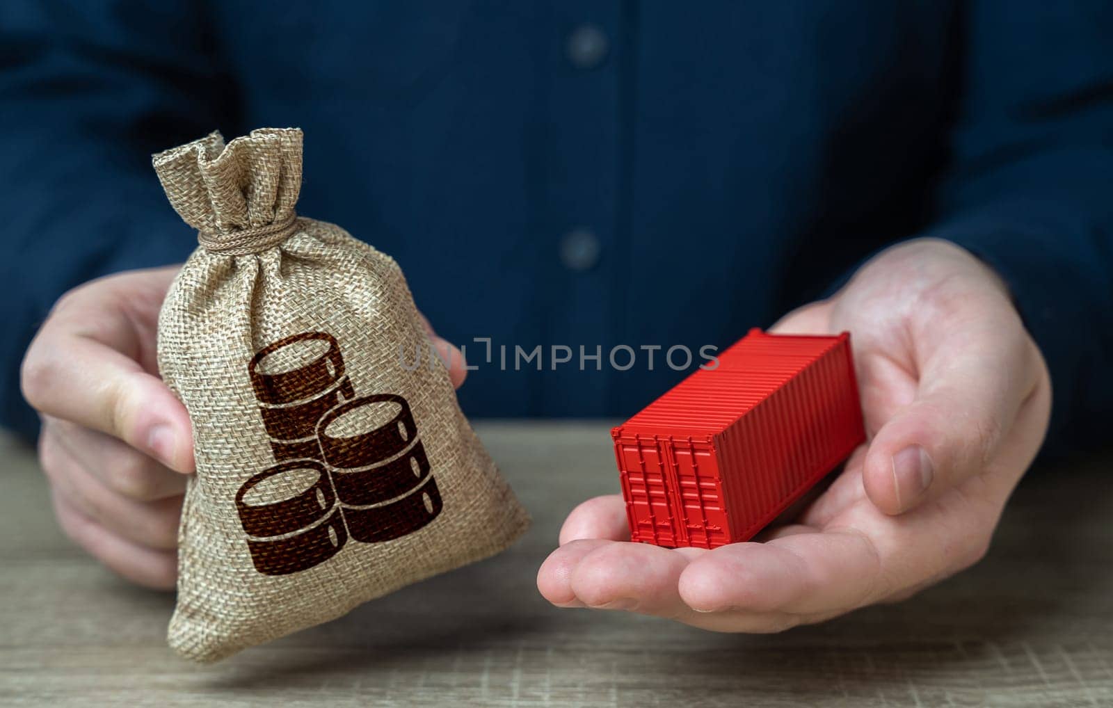 A man holds a shipping container and a money bag. Transportation and freight of goods and cargo through ports or overland routes. Trade and delivery. Distribution logistics worldwide.