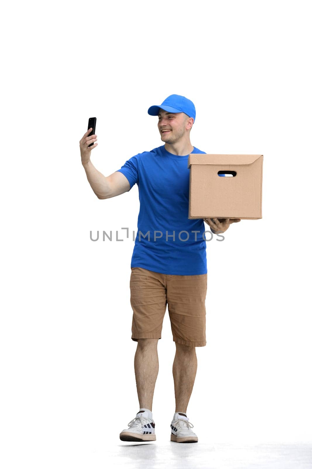 Male deliveryman, on a white background, full-length, with a phone and box.