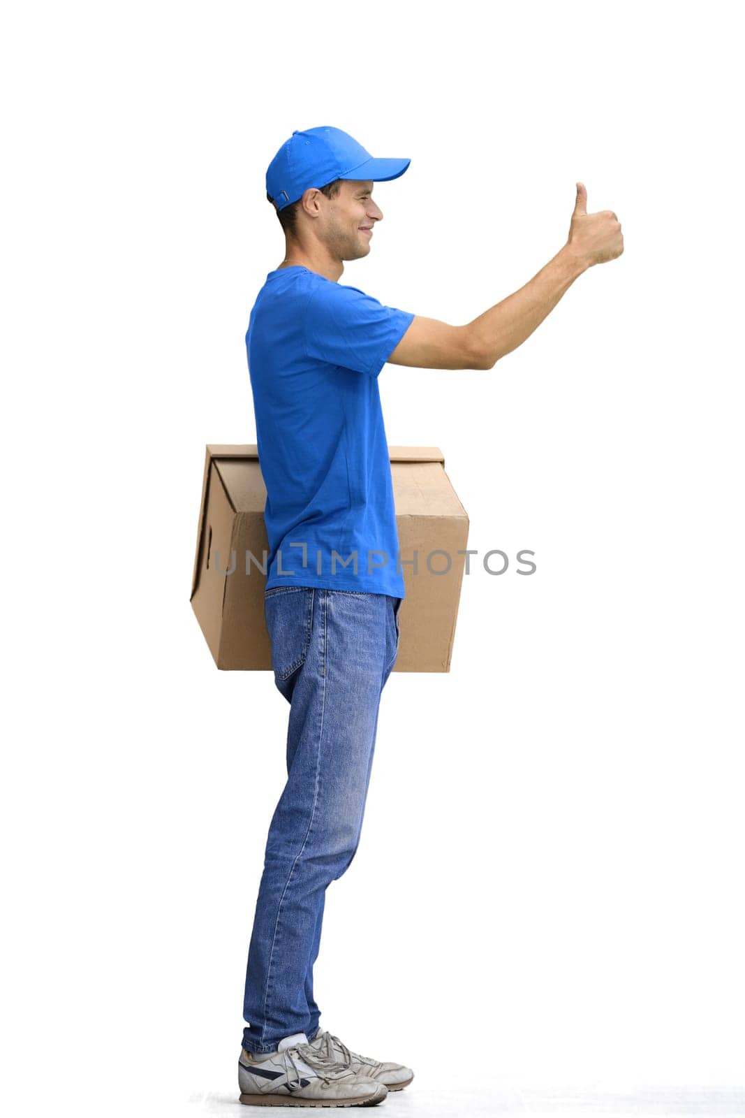 A male deliveryman, on a white background, in full height, with a box, shows a thumbs up by Prosto
