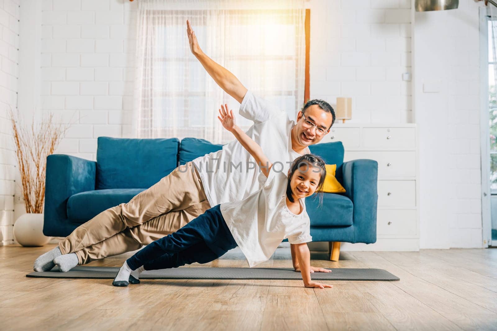 A father and his daughter create a harmonious family moment as they practice yoga at home emphasizing togetherness happiness and muscle strength their smiles radiating positivity.