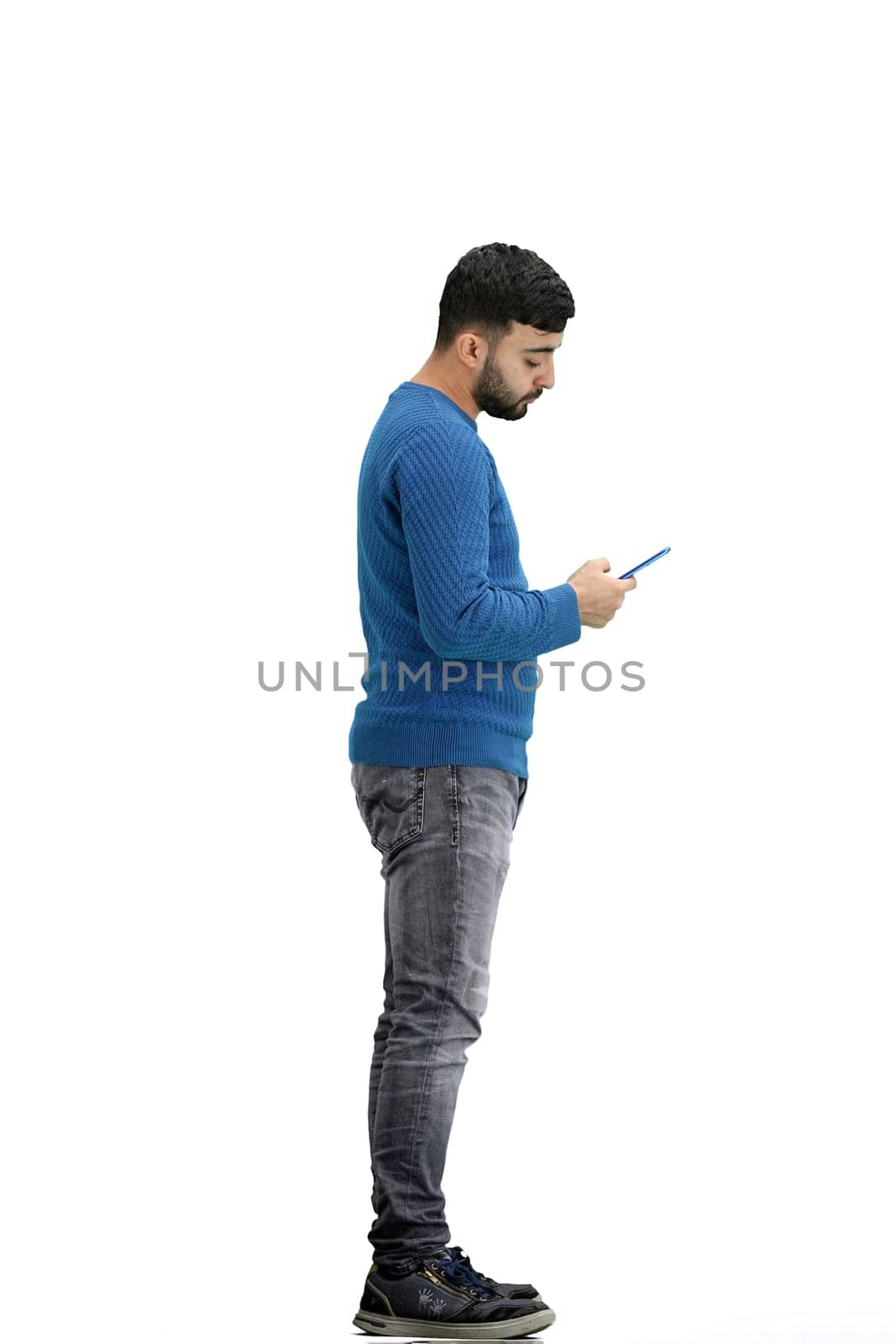 A man, full-length, on a white background, uses on the phone.