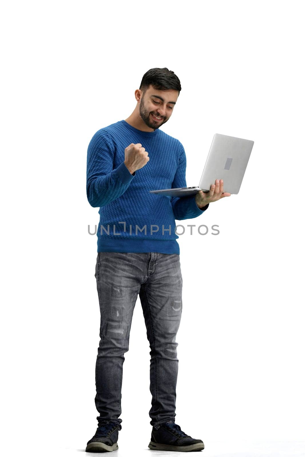 A man, full-length, on a white background, uses a laptop.