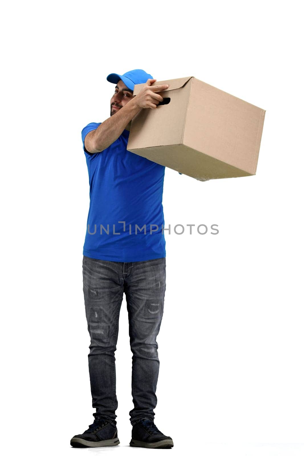 The deliveryman, in full height, on a white background, shakes the box.