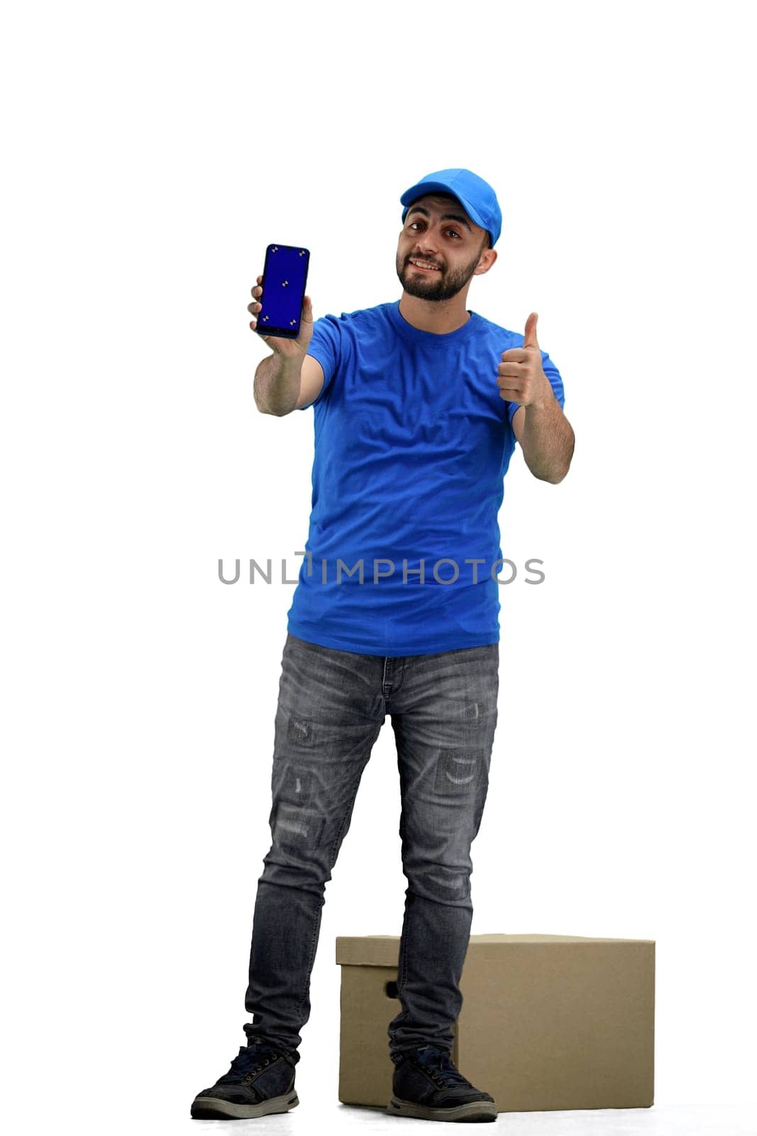 The deliveryman, in full height, on a white background, shows the phone.