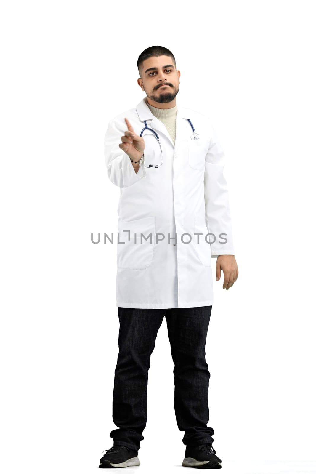 The doctor, in full height, on a white background, shows a forbidding sign.