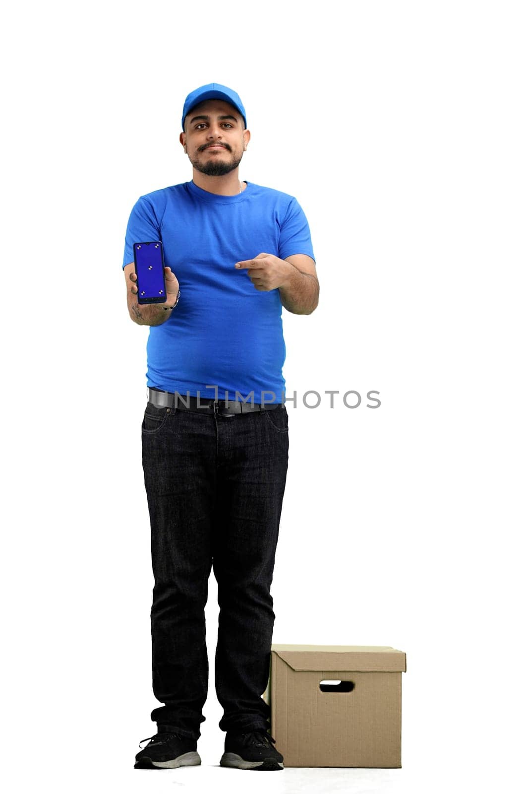 The deliveryman, in full height, on a white background, with a box, shows the phone.
