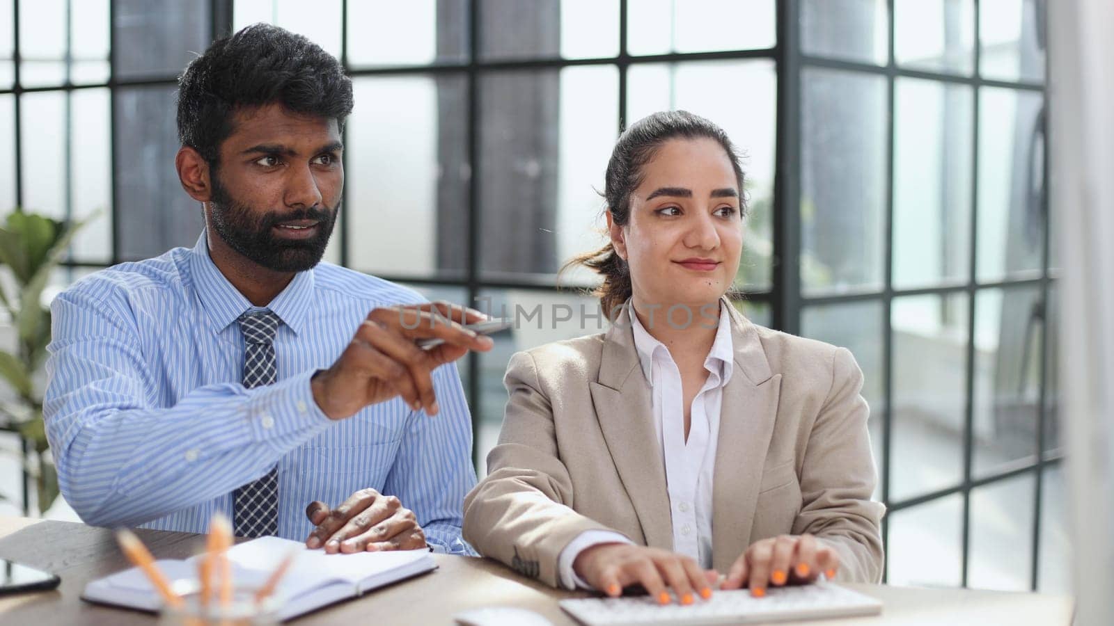 Young indian mentor coach talking with female colleague teaching trainee having business conversation with work colleague by Prosto