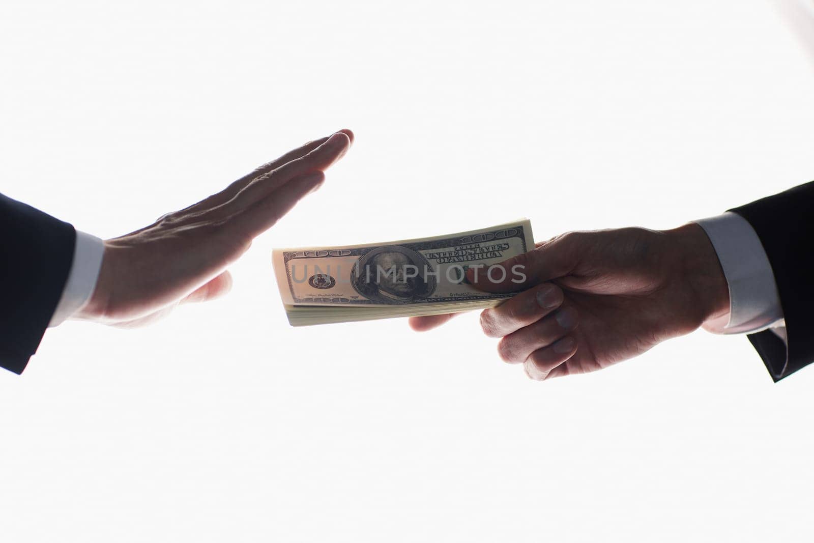 A man's hand in a black suit holds out a wad of money, which refuses. On a white background by Prosto