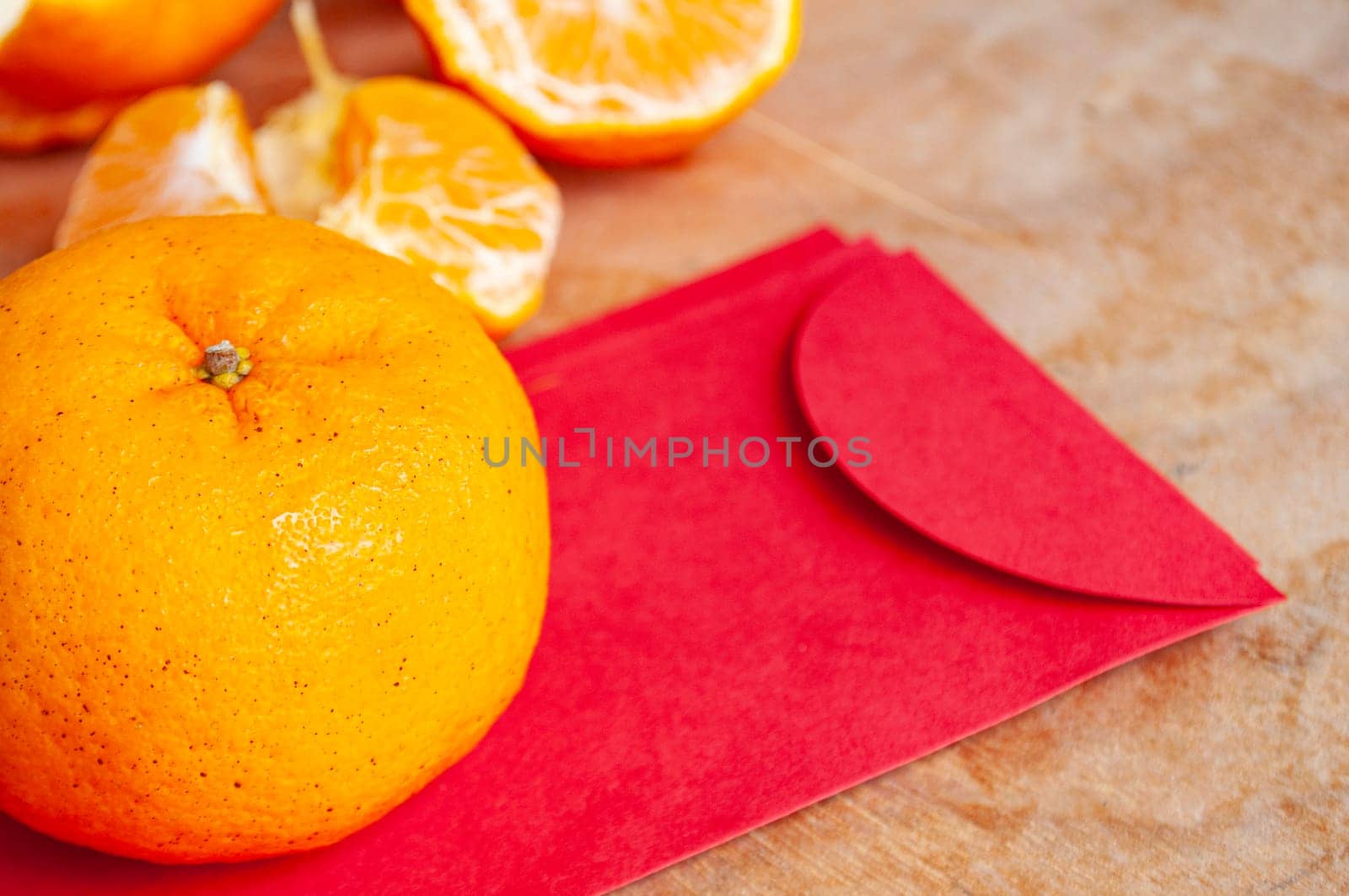 Mandarin orange on top of Chinese New Year red packet. Chinese New Year celebration concept.