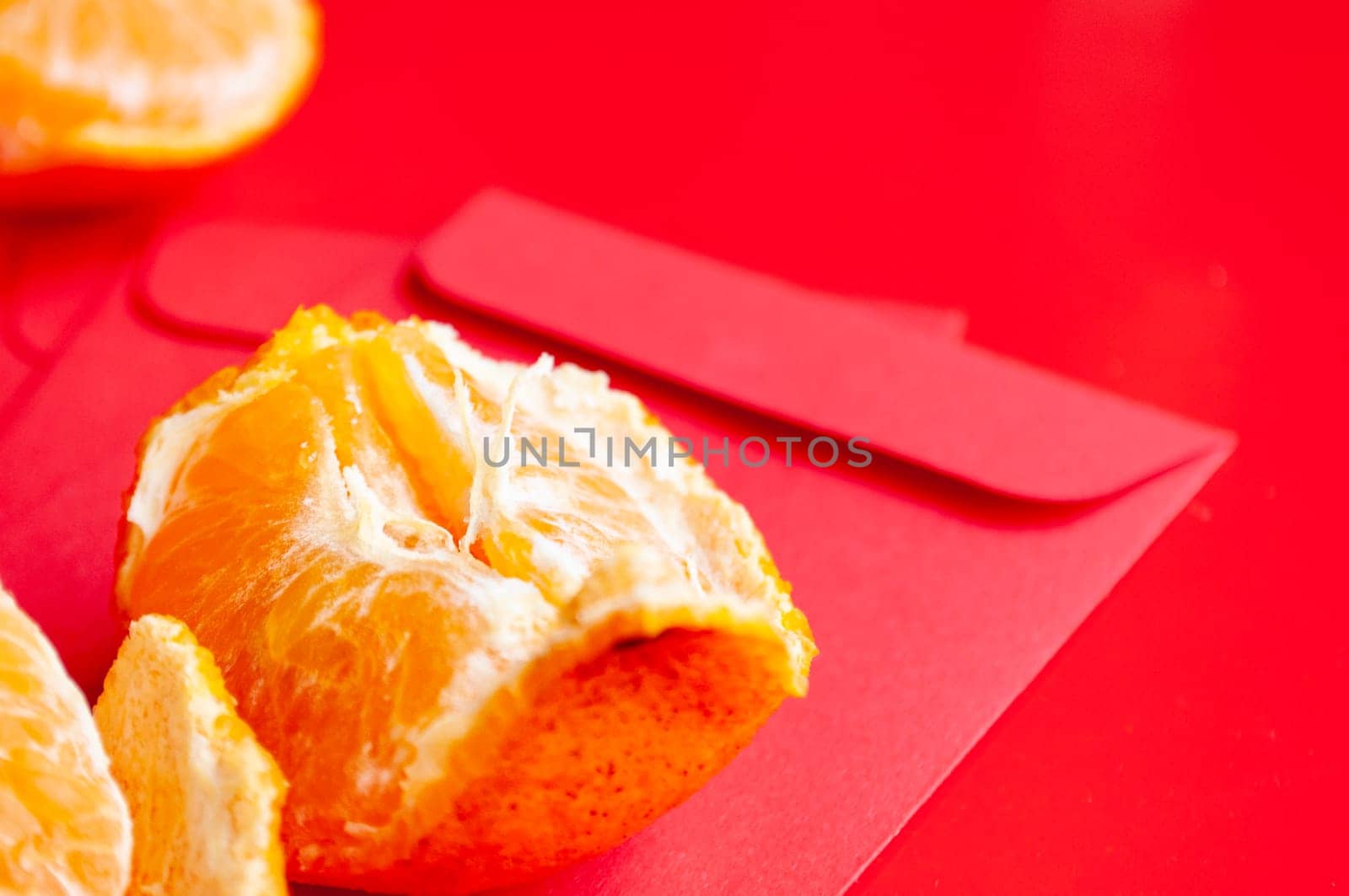 Peal Mandarin oranges on top of Chinese New Year red packet. Chinese New Year celebration concept.
