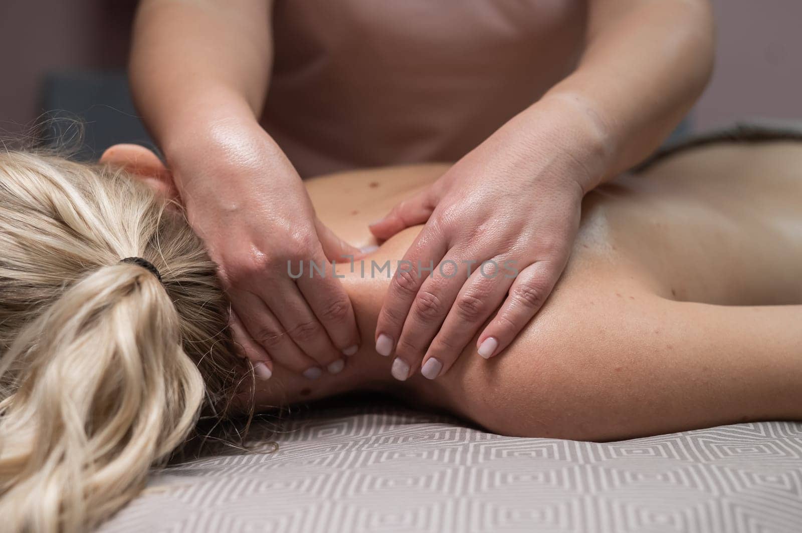 A woman gives a manual massage to a client. Close-up