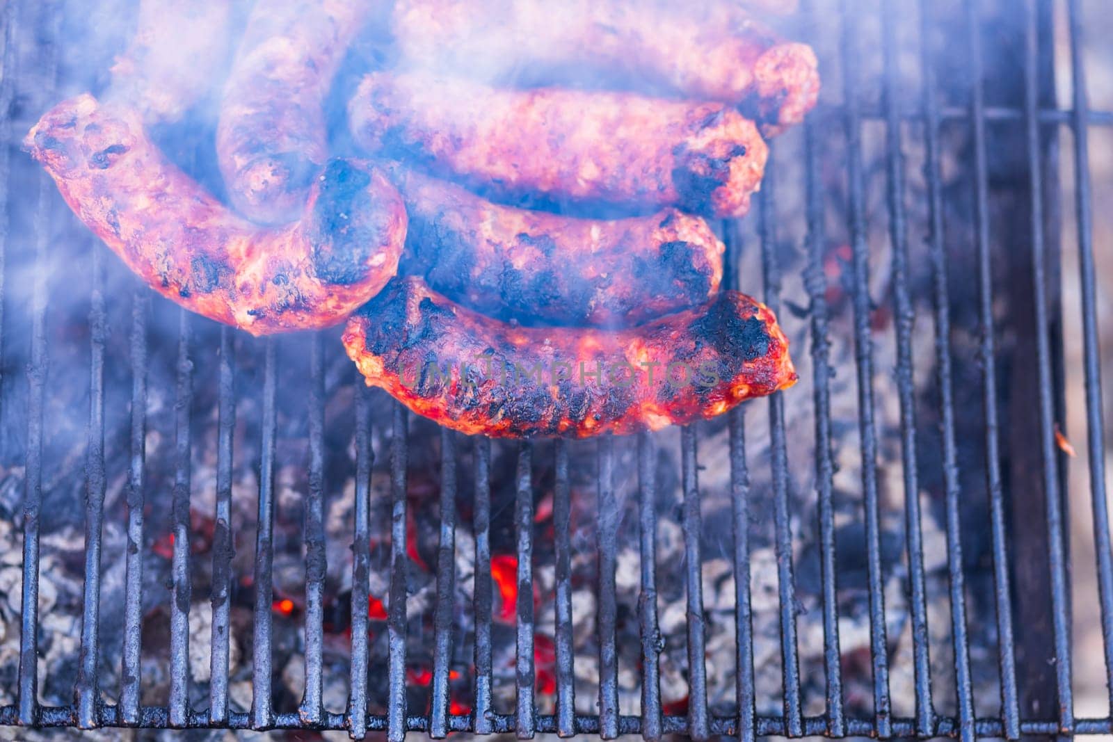 Sausages grilled on a charcoal barbeque. Top view of tasty barbecue, food concept, food on grill and detail of sausages on the grill