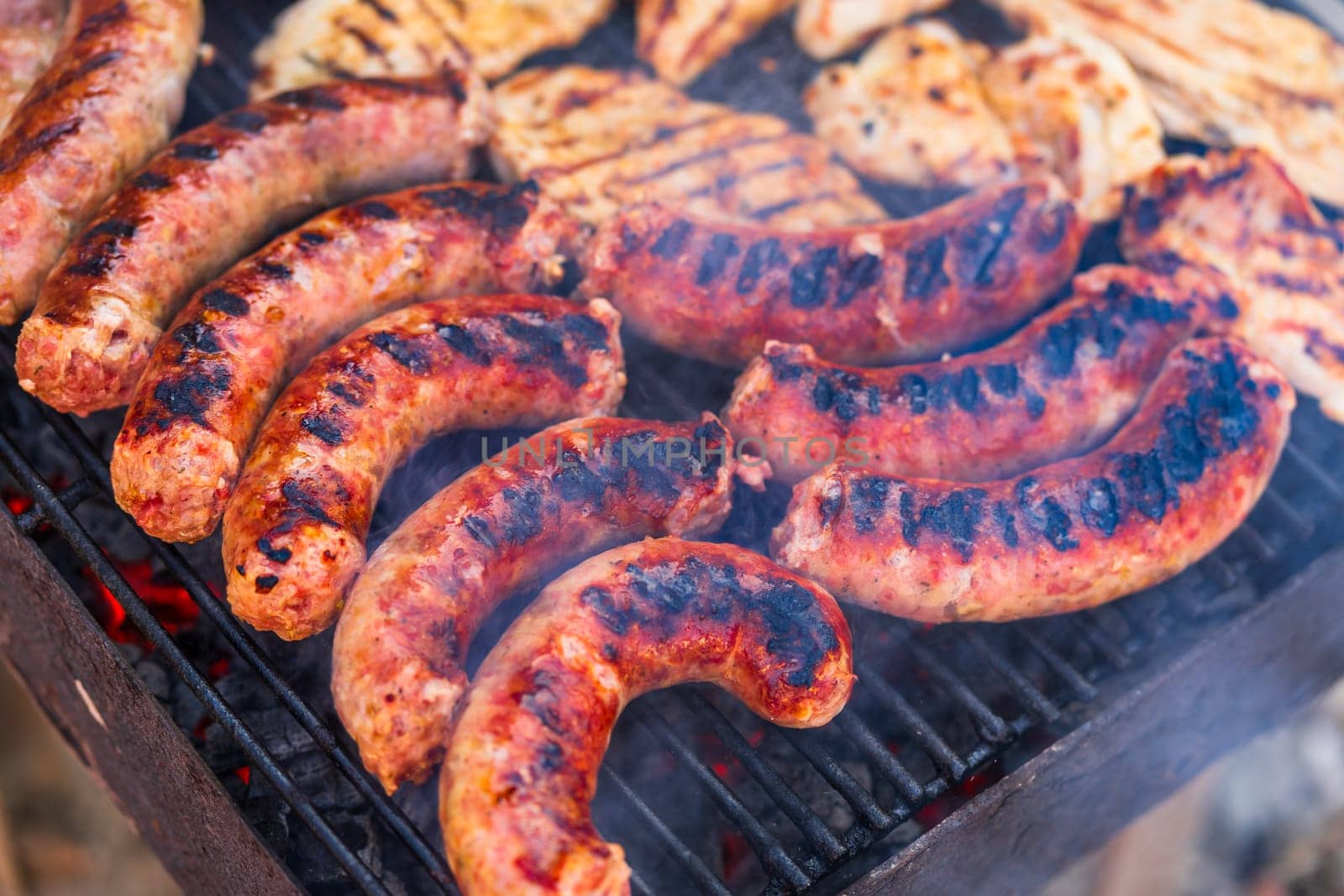 Grilling sausages and pork chops on barbecue grill. BBQ in the garden