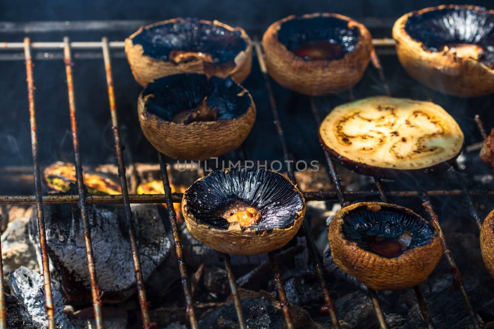 Tasty champignon  mushrooms and veggies being cooked on charcoal grill