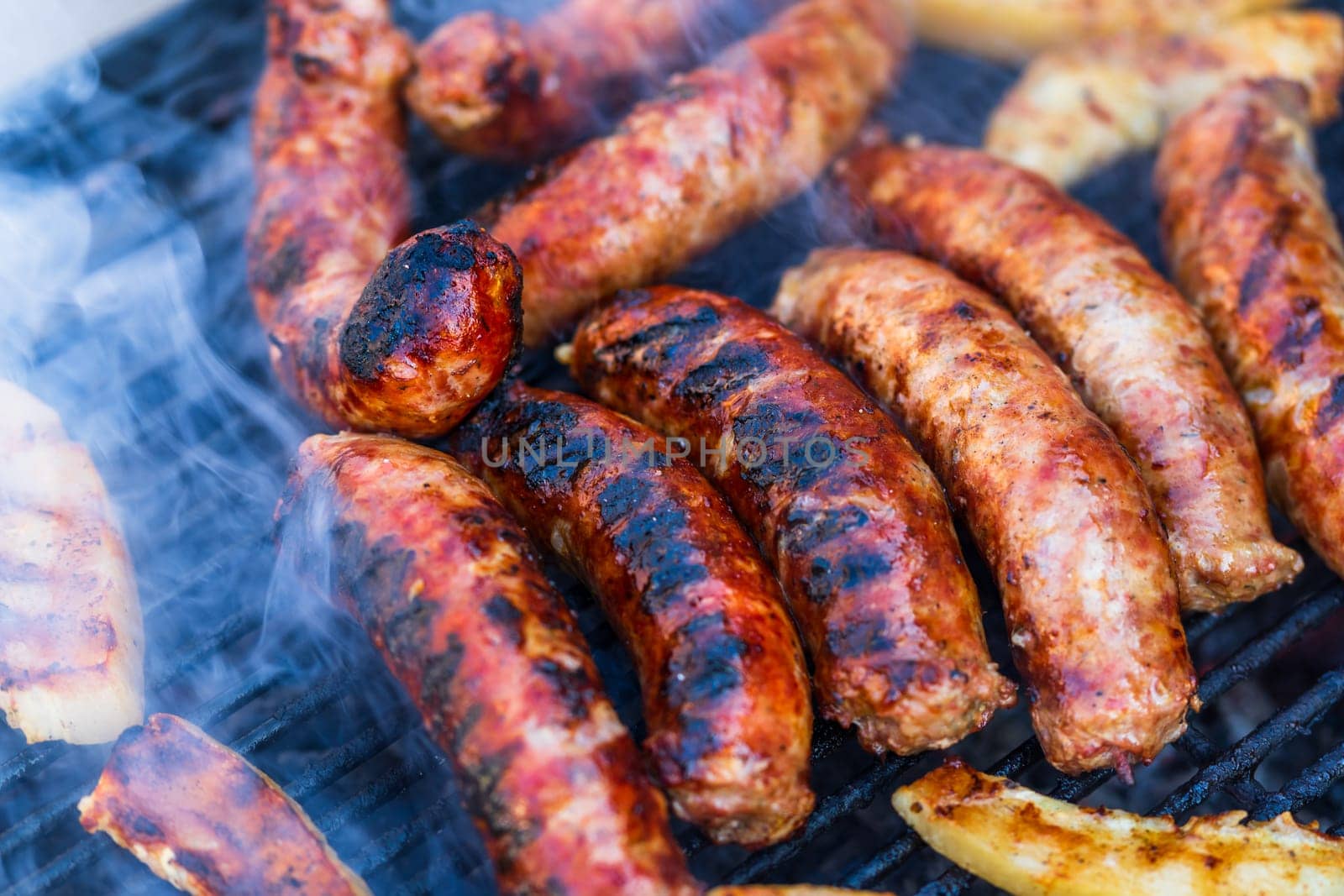 Pork meat and sausages grilled on a charcoal barbeque. Top view of tasty barbecue, food concept, food on grill and detail of food on the grill