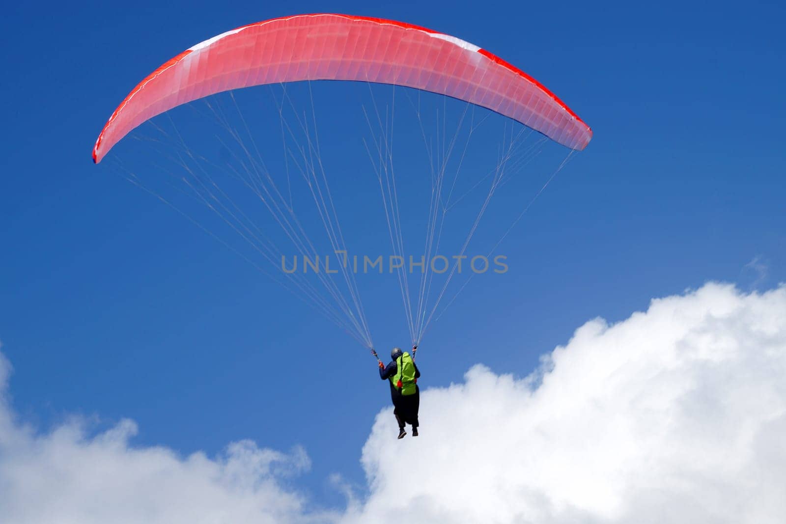 man flying on a parachute wing with a blue sky close-up