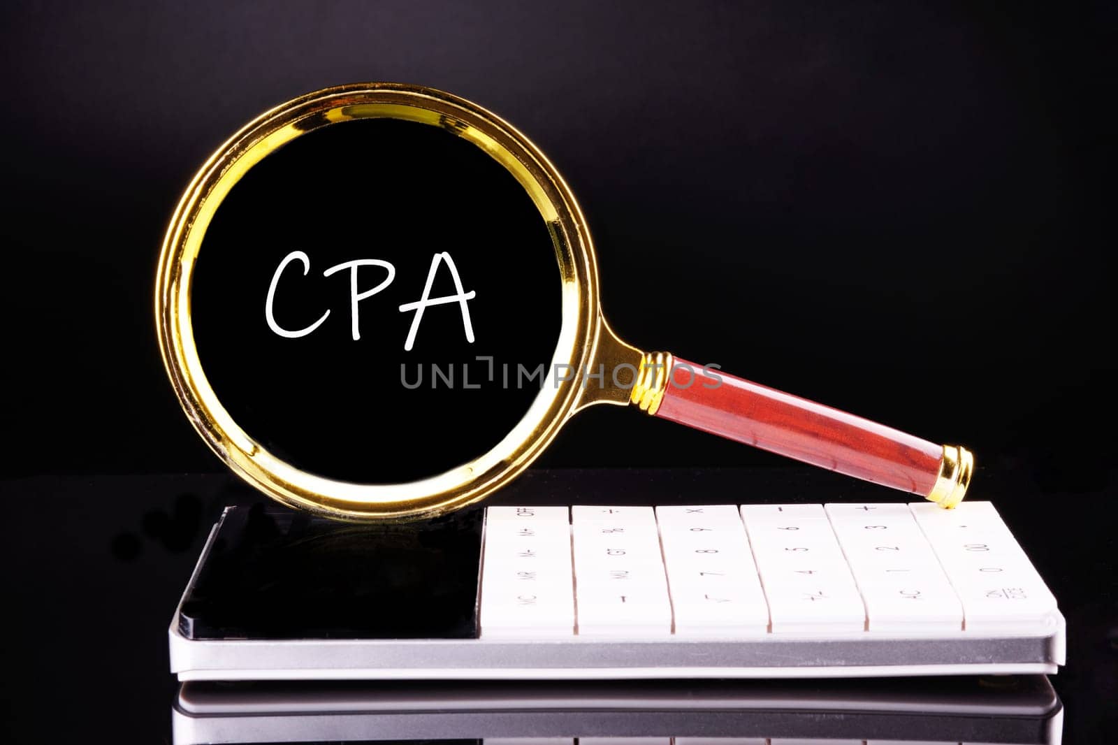 CPA, Certified Public Accountant or Cost per Action a word through a magnifying glass on a calculator on a black background