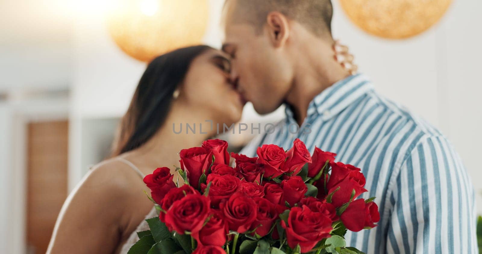 Couple, flowers and kiss for anniversary celebration, marriage and loyalty or commitment to love. People, happy and romance for relationship milestone, bonding and plant gift for support at home.