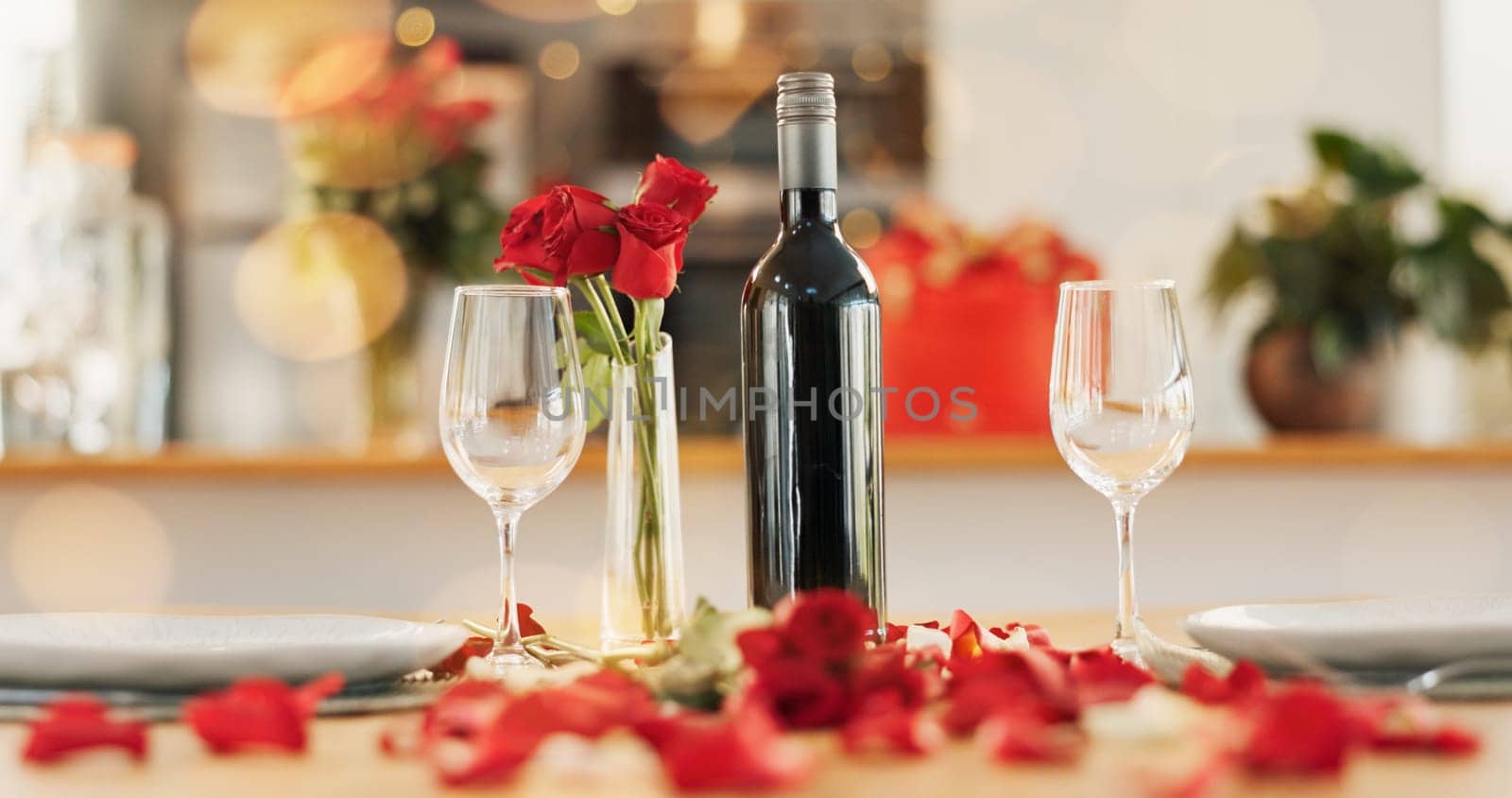 Wine, flowers and romance on valentines day for celebration of love, anniversary or honeymoon in still life. Glass, dinner and elegant date in dining room of home for event, milestone or occasion.