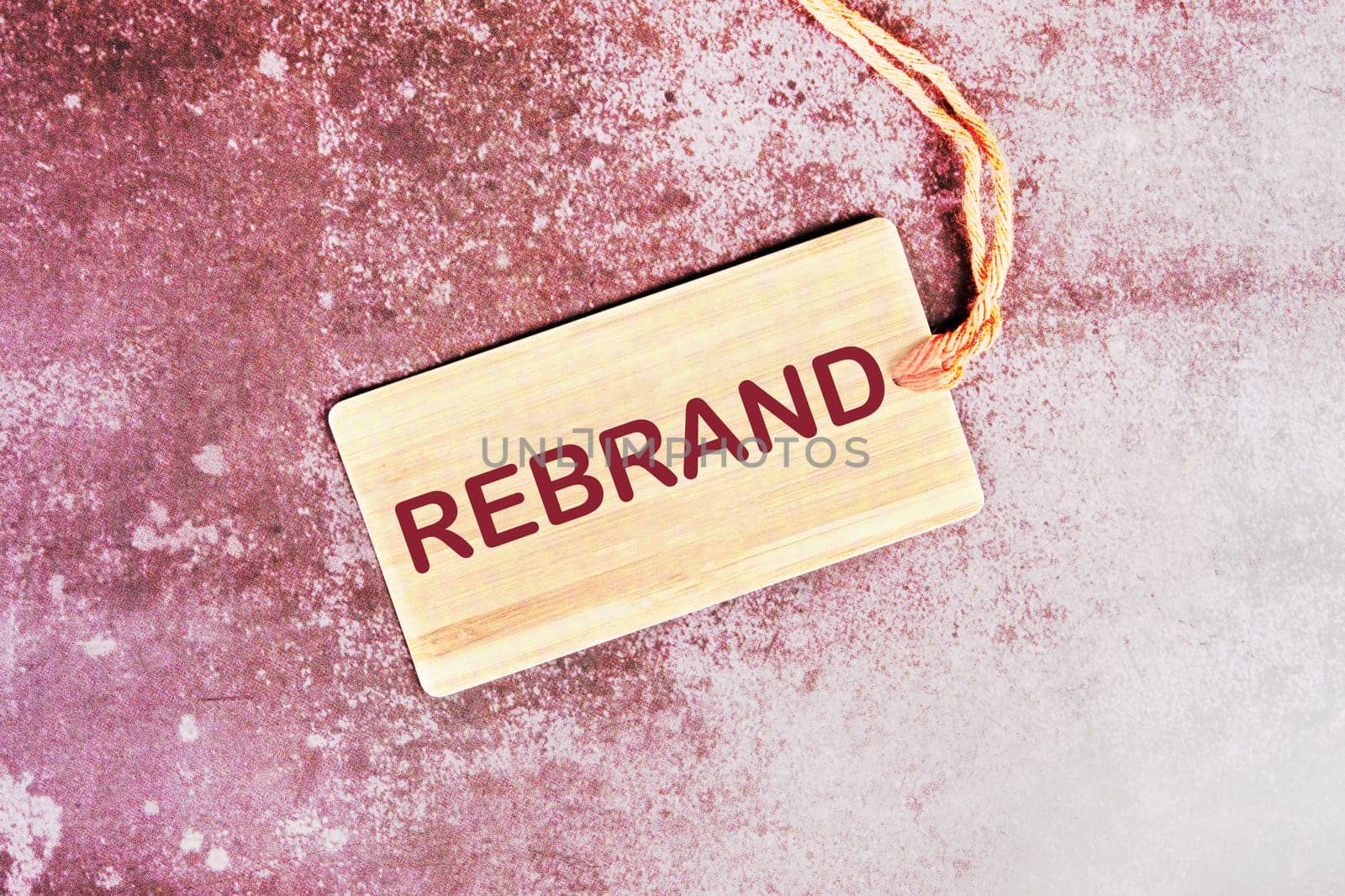 REBRAND word written on a card with a rope on an abstract background