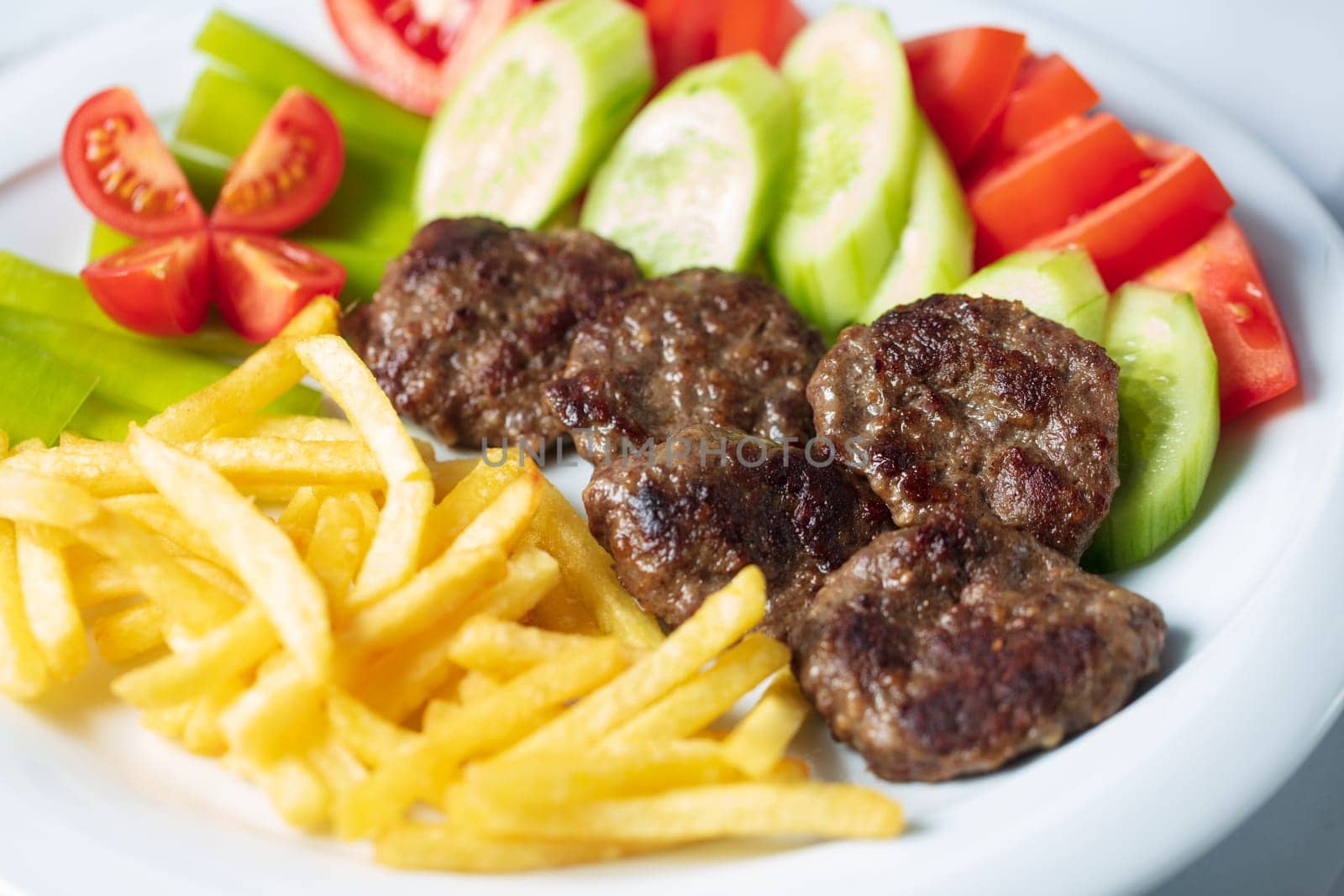 Traditional Turkish meatballs served with French fries tomatoes . High quality photo