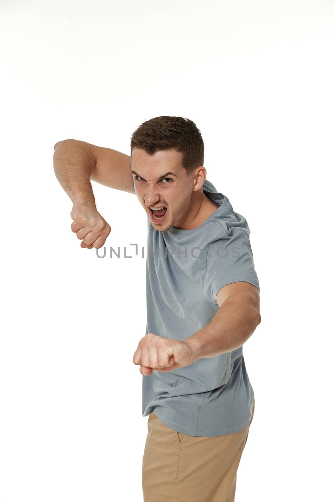 annoyed angry man fighting on white studio background