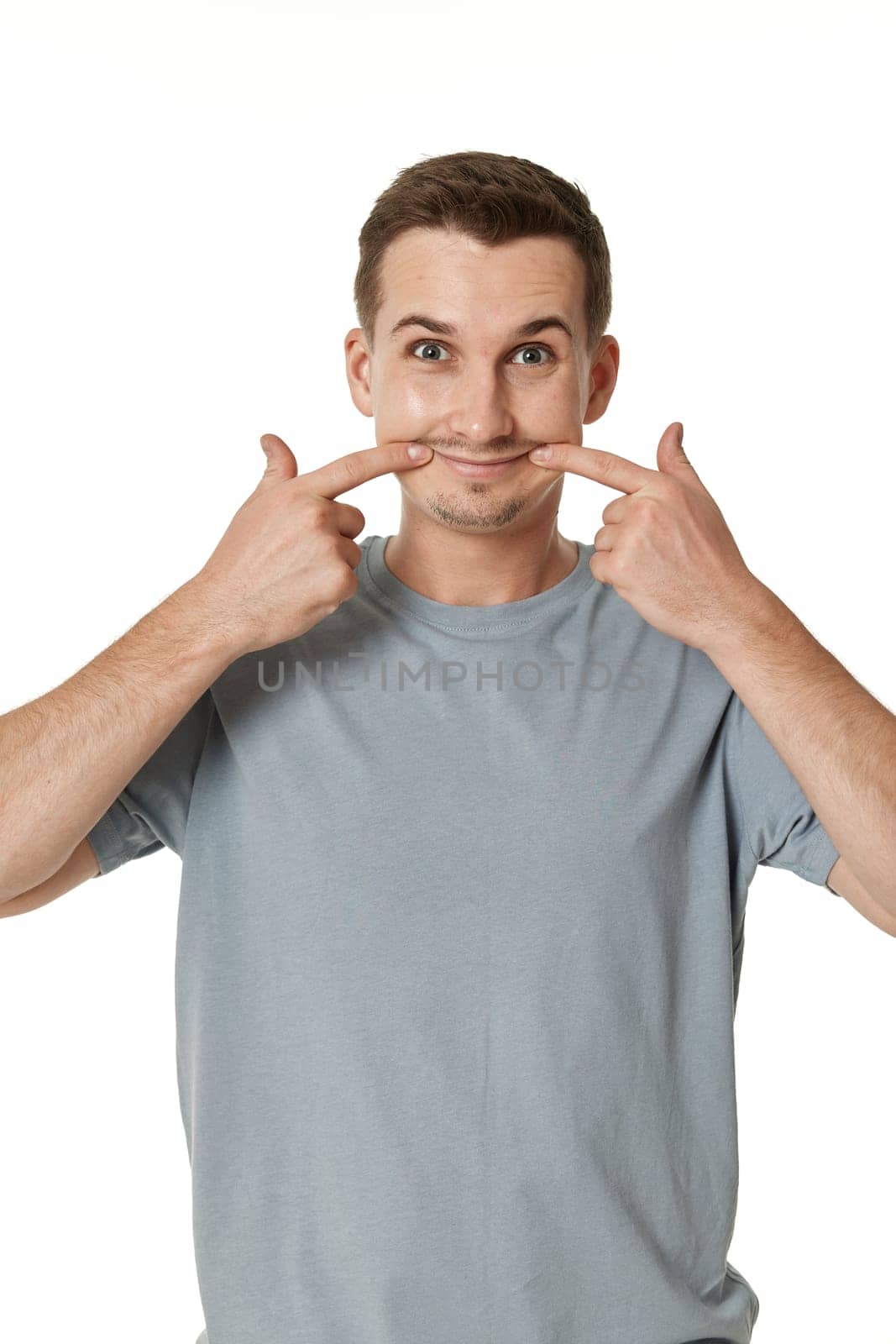 portrait of young smiling funny man grimacing on white background