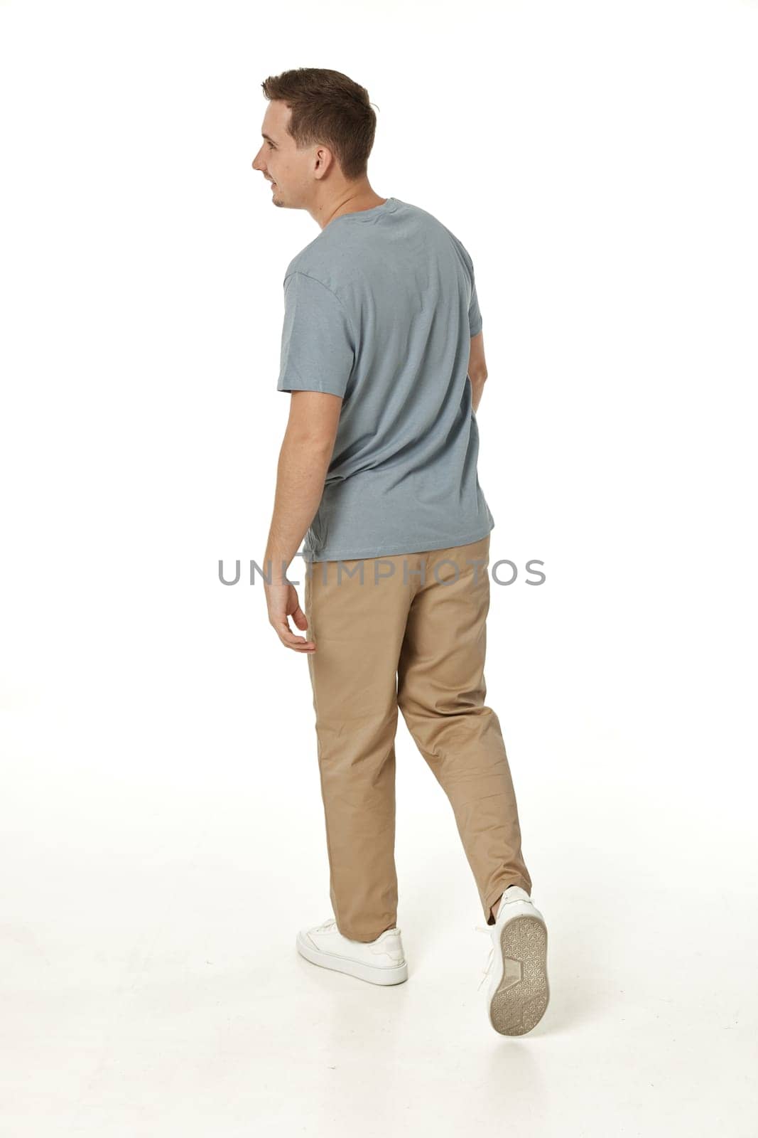 portrait of young smiling man on white background, rear view