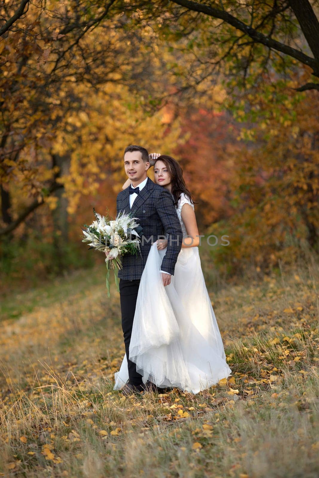 bride in white wedding dress and groom outdoor by erstudio