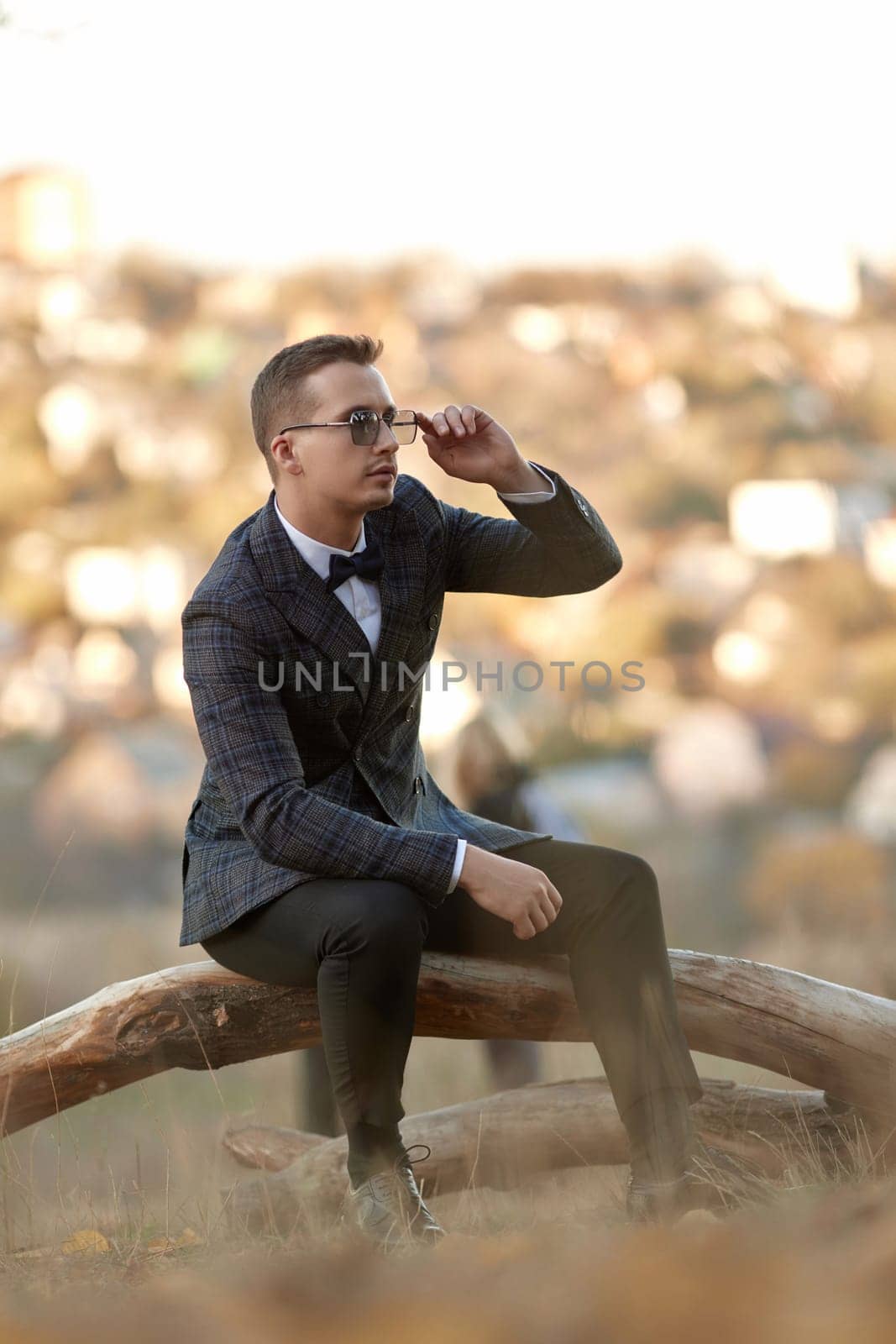 Handsome young man in classic checked suit and sunglasses outdoor