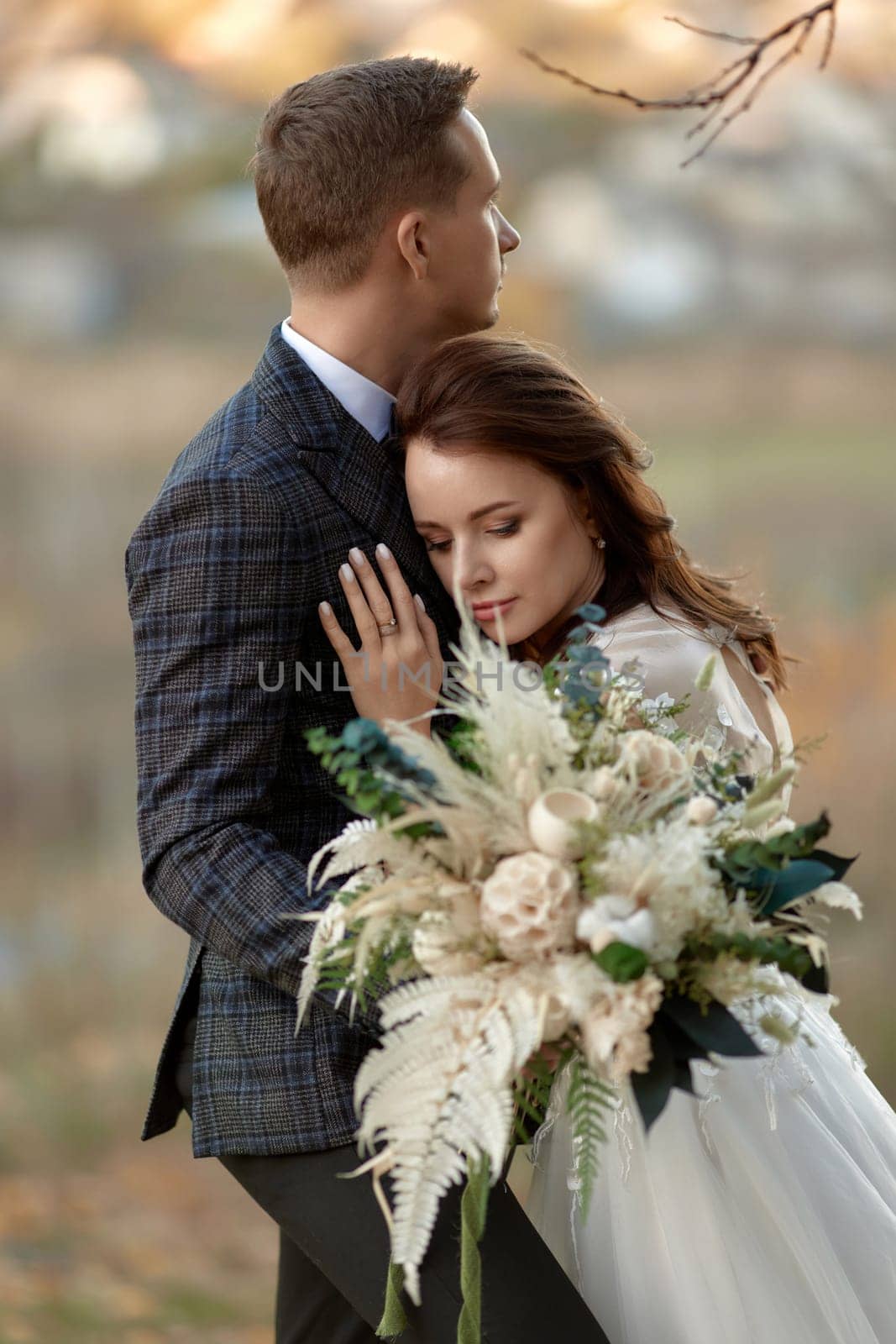 beautiful sensual bride in white wedding dress and groom standing outdoor on natural background