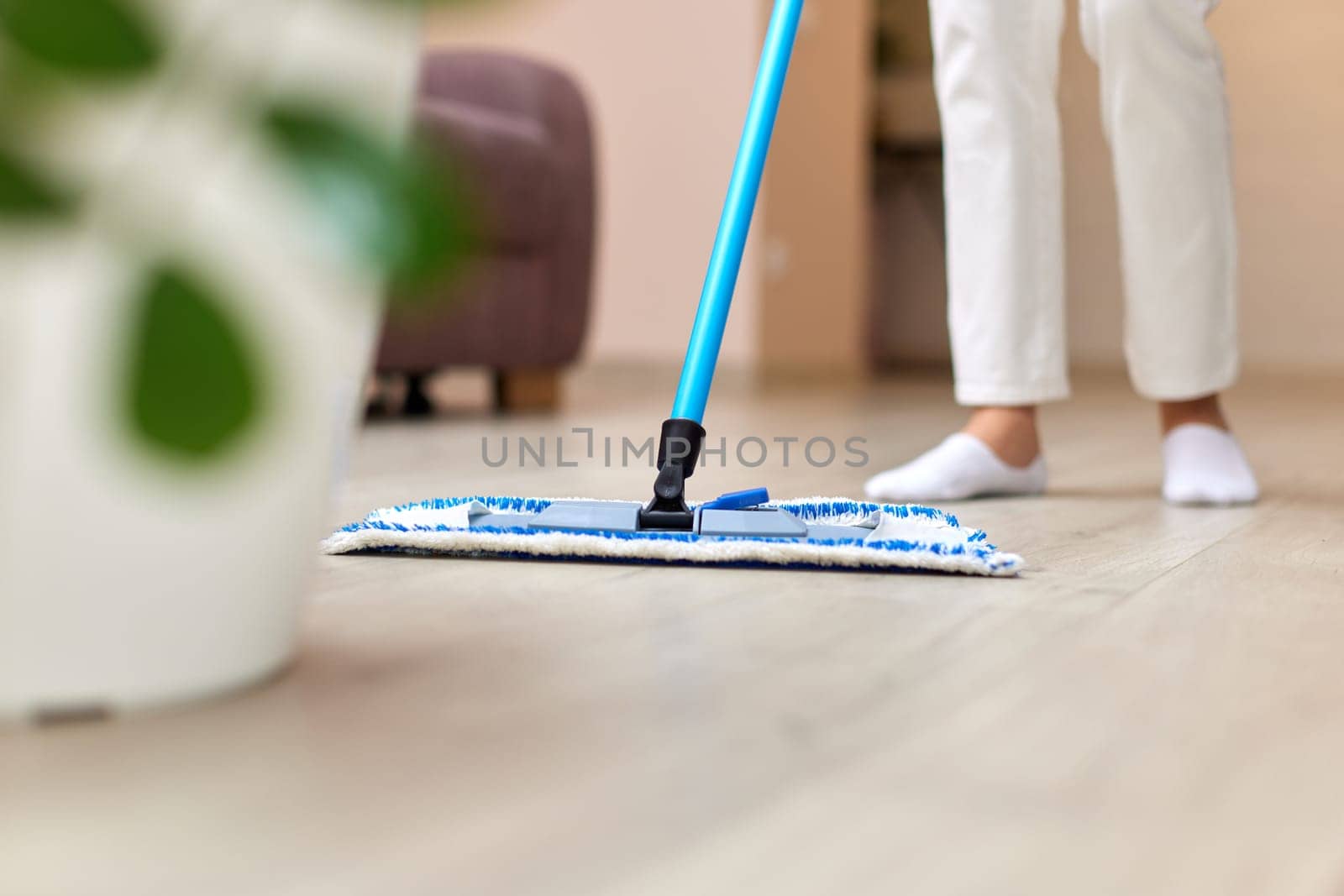 young woman cleaning and mopping floor at living room, daily housekeeping , Cropped