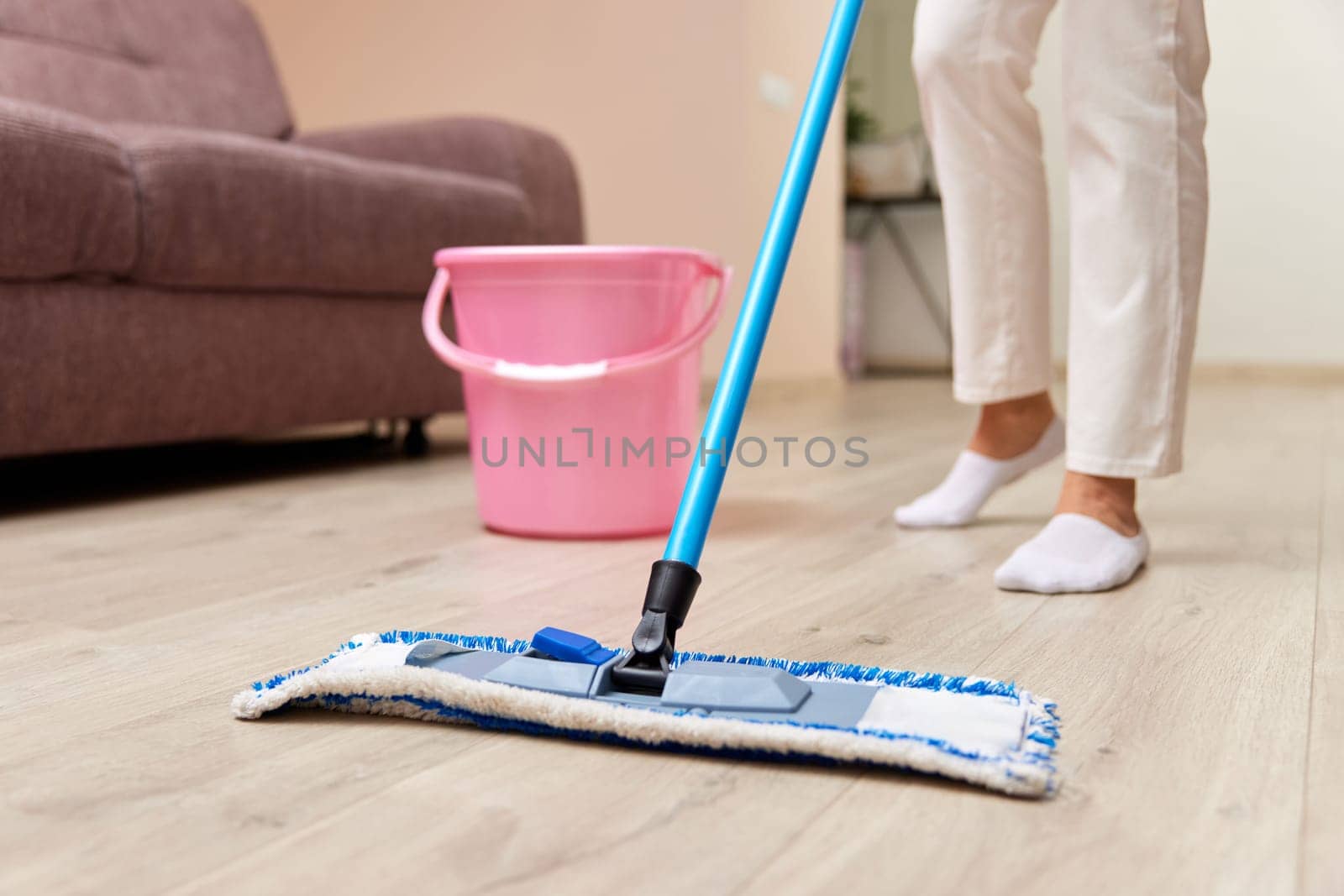 young woman cleaning and mopping floor at living room, daily housekeeping , close-up