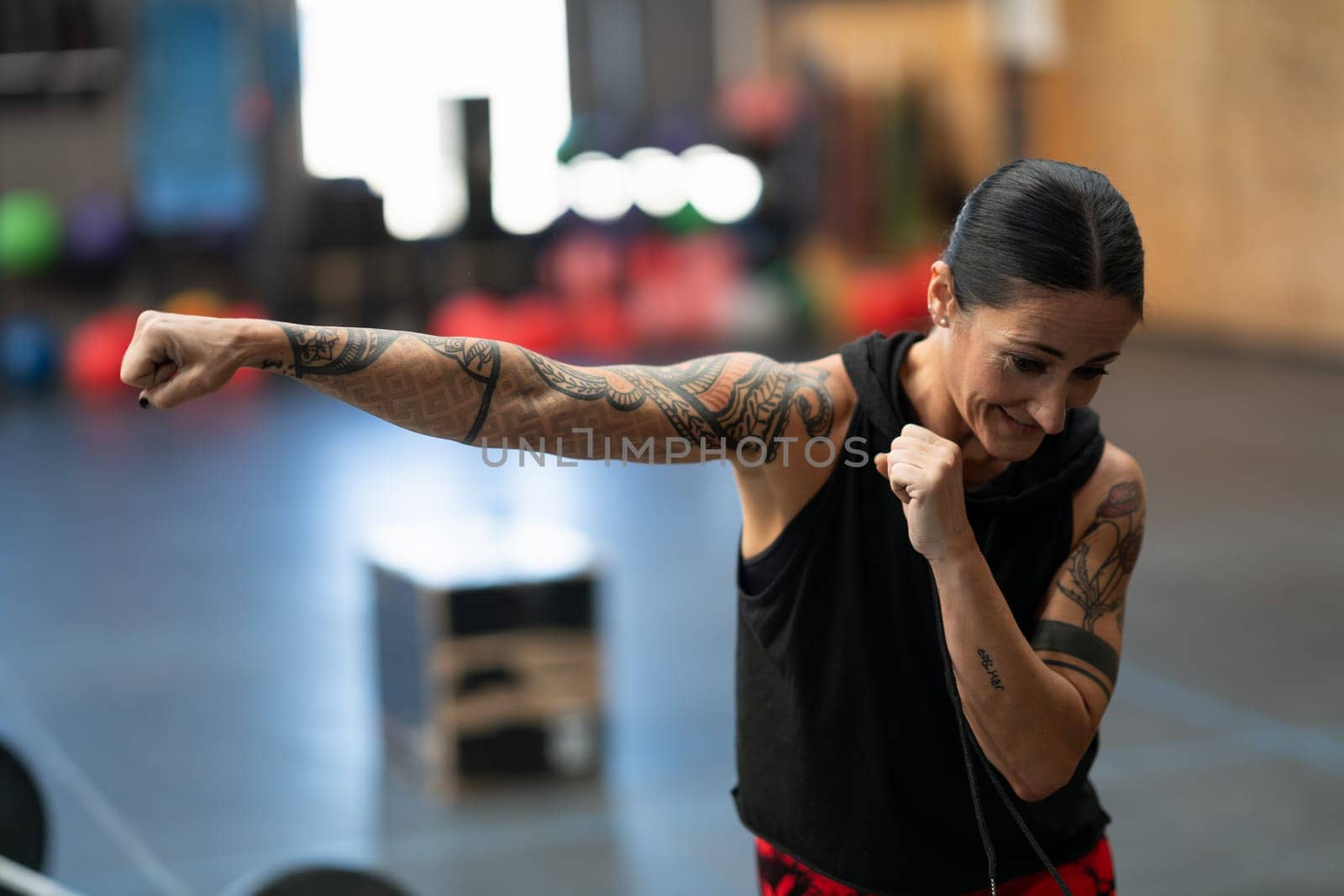 Close-up of a mature sportive woman practicing shadowboxing in a gym