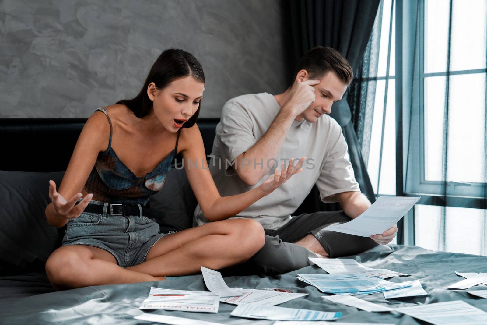 Stress young family couple worried about overwhelming and massive credit card bill or final mortgage loan notification. Modern family financial crisis from over spending online shopping. Unveiling