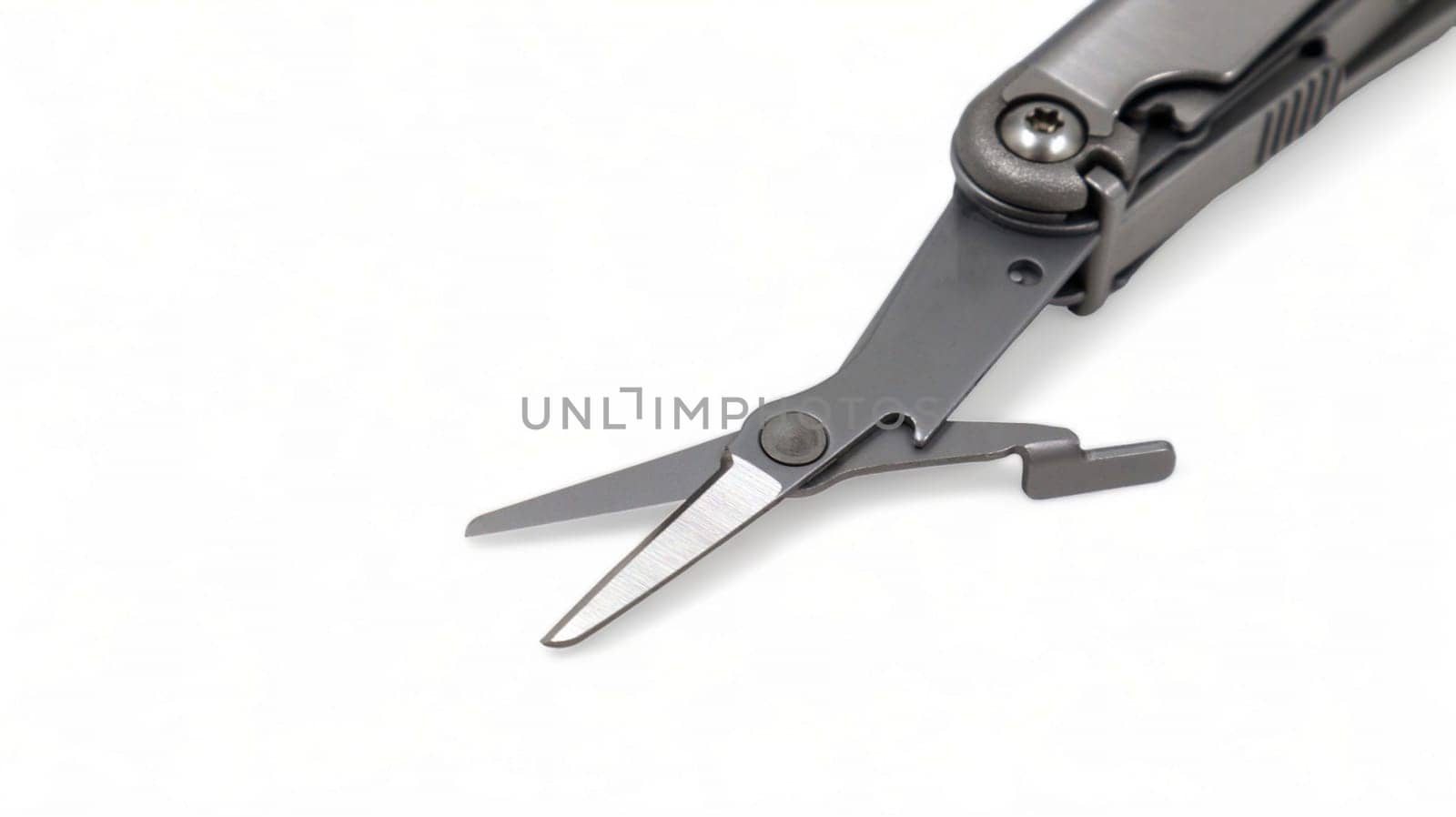 The scissors tool is pulled out of the multitool. Modern steel multitool with many tools isolated on white background. Compact and portable product. Pocket knife. EDC concept. Copy space