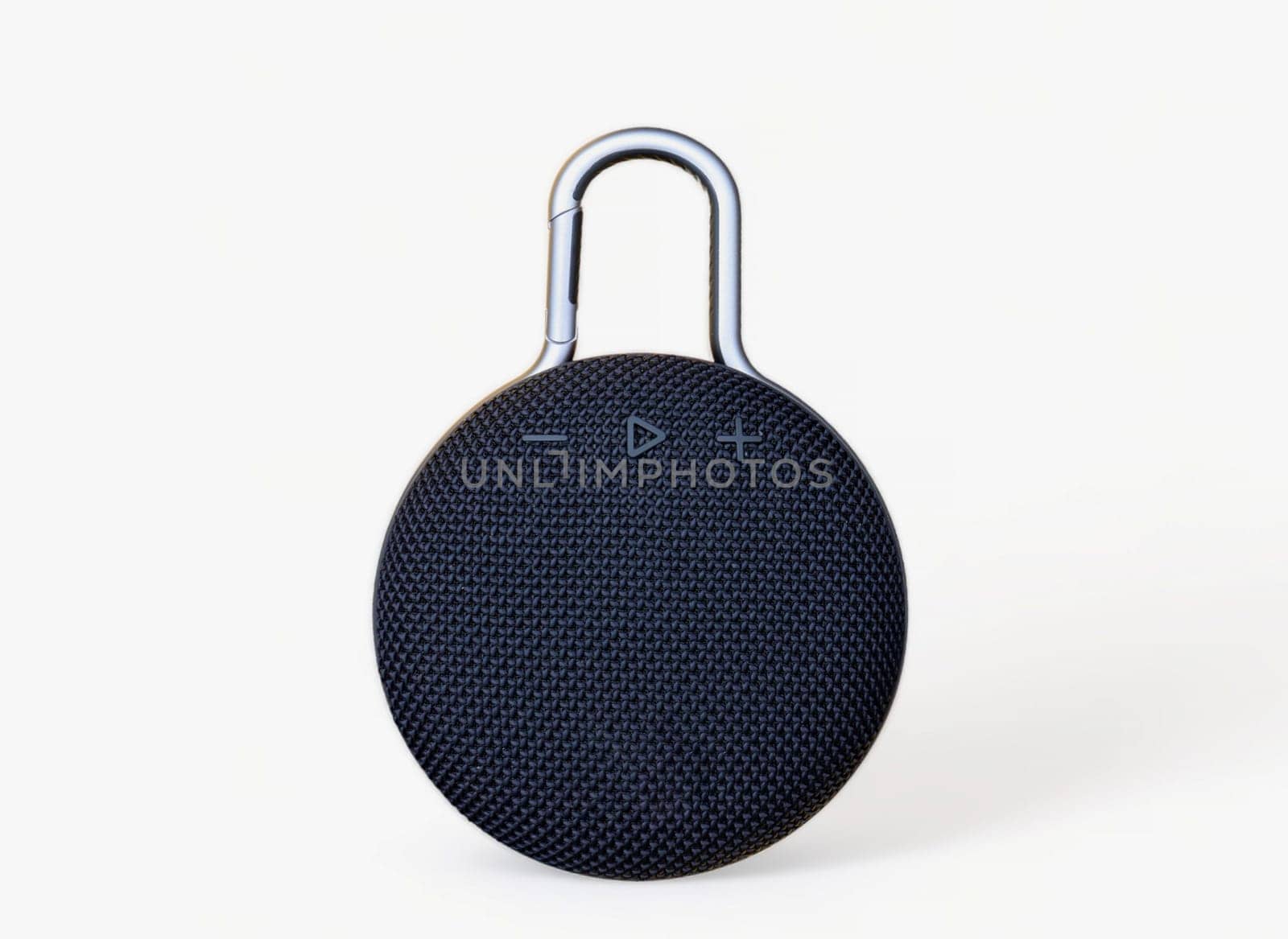 Waterproof round black speaker with carabiner. Digital music and sound concept. Mini, suitable for travel. Modern technology concept. Smart portable wireless speaker on a white background. by Roshchyn