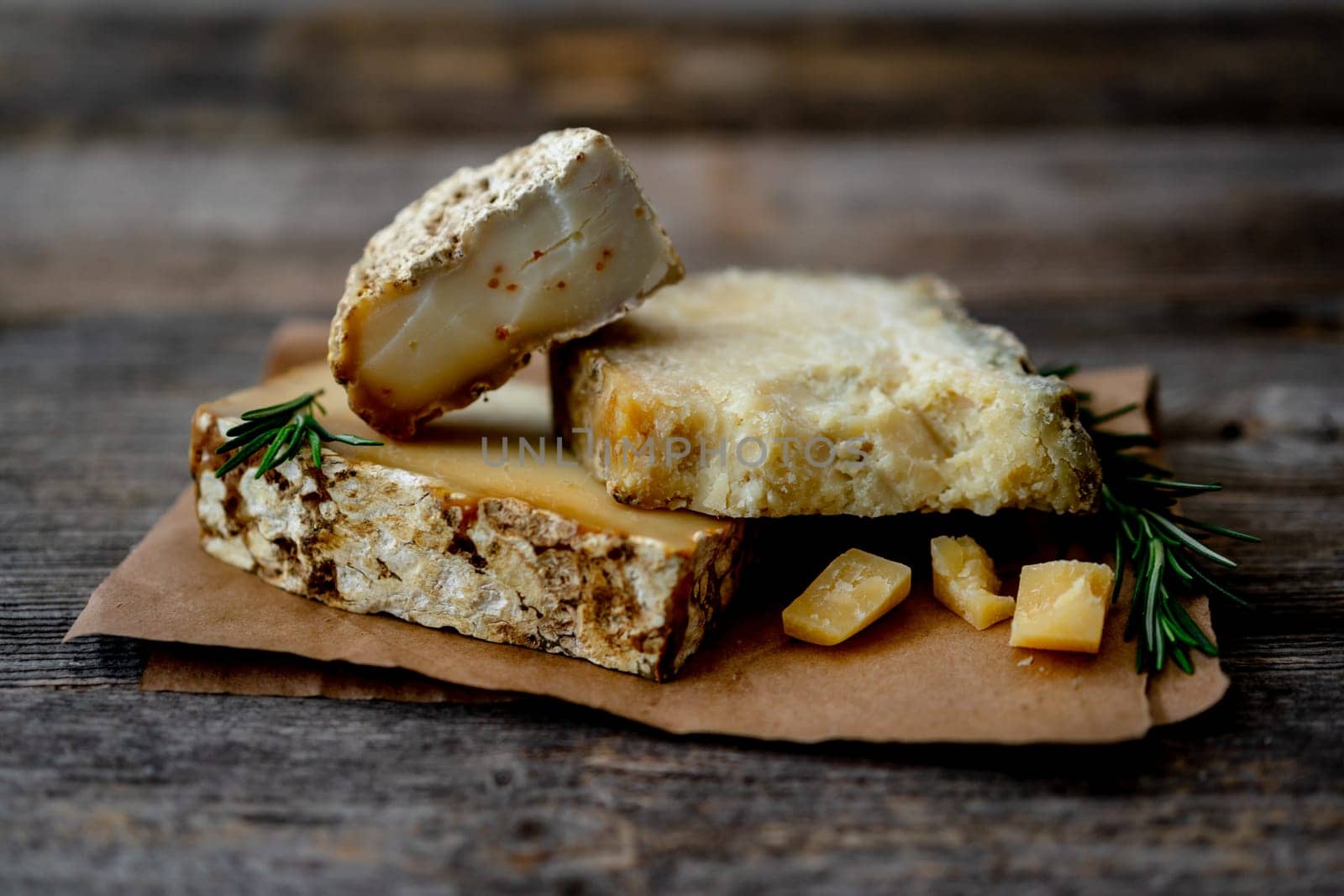 Homemade Goat Cheese On Craft Paper Rests On An Old Rustic Table