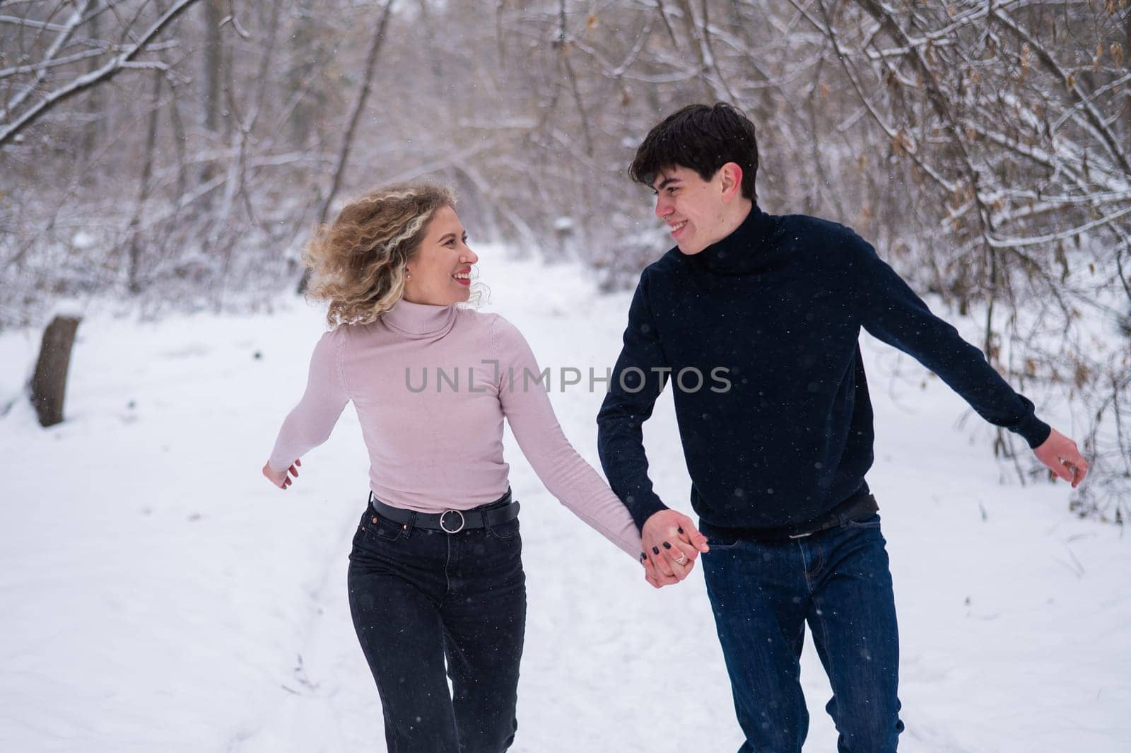 A young couple walks in the park in winter without jackets. by mrwed54