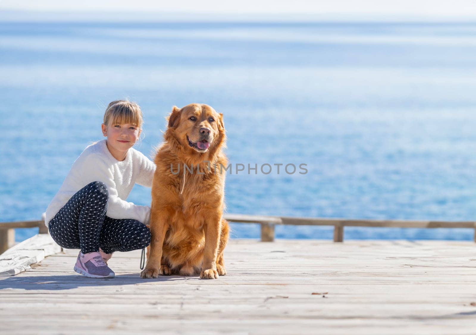 Seaside Companions: A Child and Their Golden Friend by Juanjo39