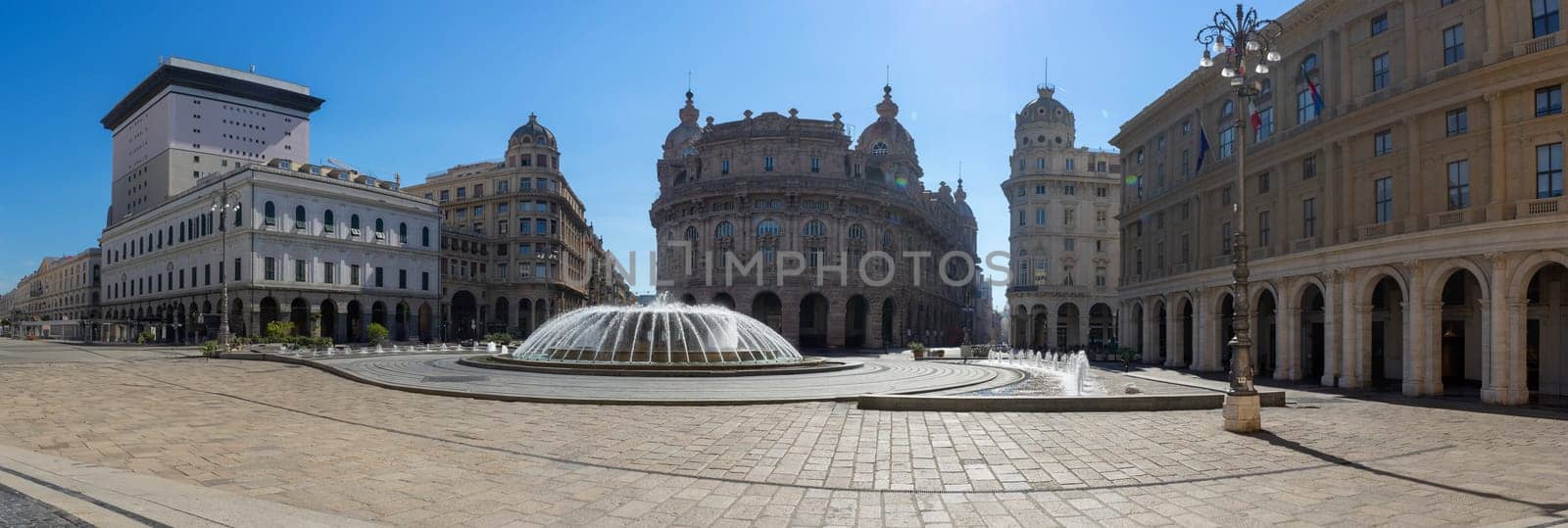 This panoramic image showcases a grand European square bathed in the soft glow of morning light. The focal point is an elegant fountain, its water sparkling in the sun, surrounded by an array of stately buildings with classic architectural details, all under a clear blue sky.