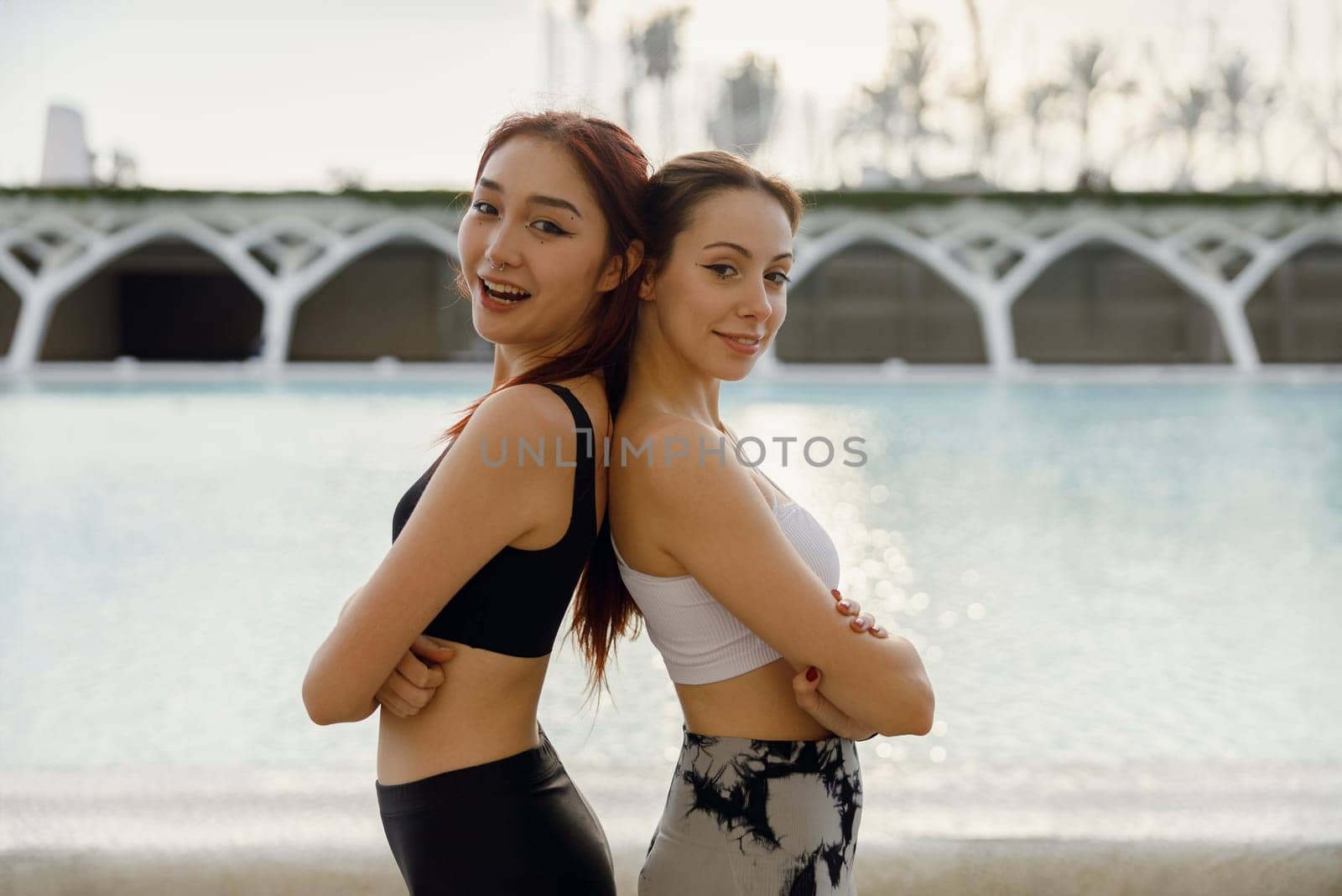Young smiling female sportswomen have a rest after morning jogging outdoors and looks camera by Yaroslav_astakhov