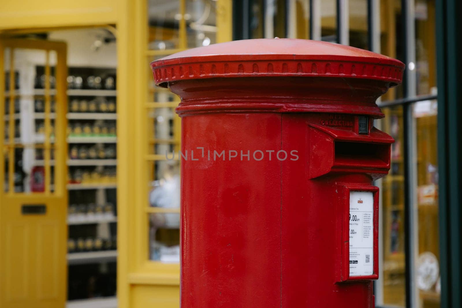 Red pillar mail box on a busy street in Canterbury by Suteren