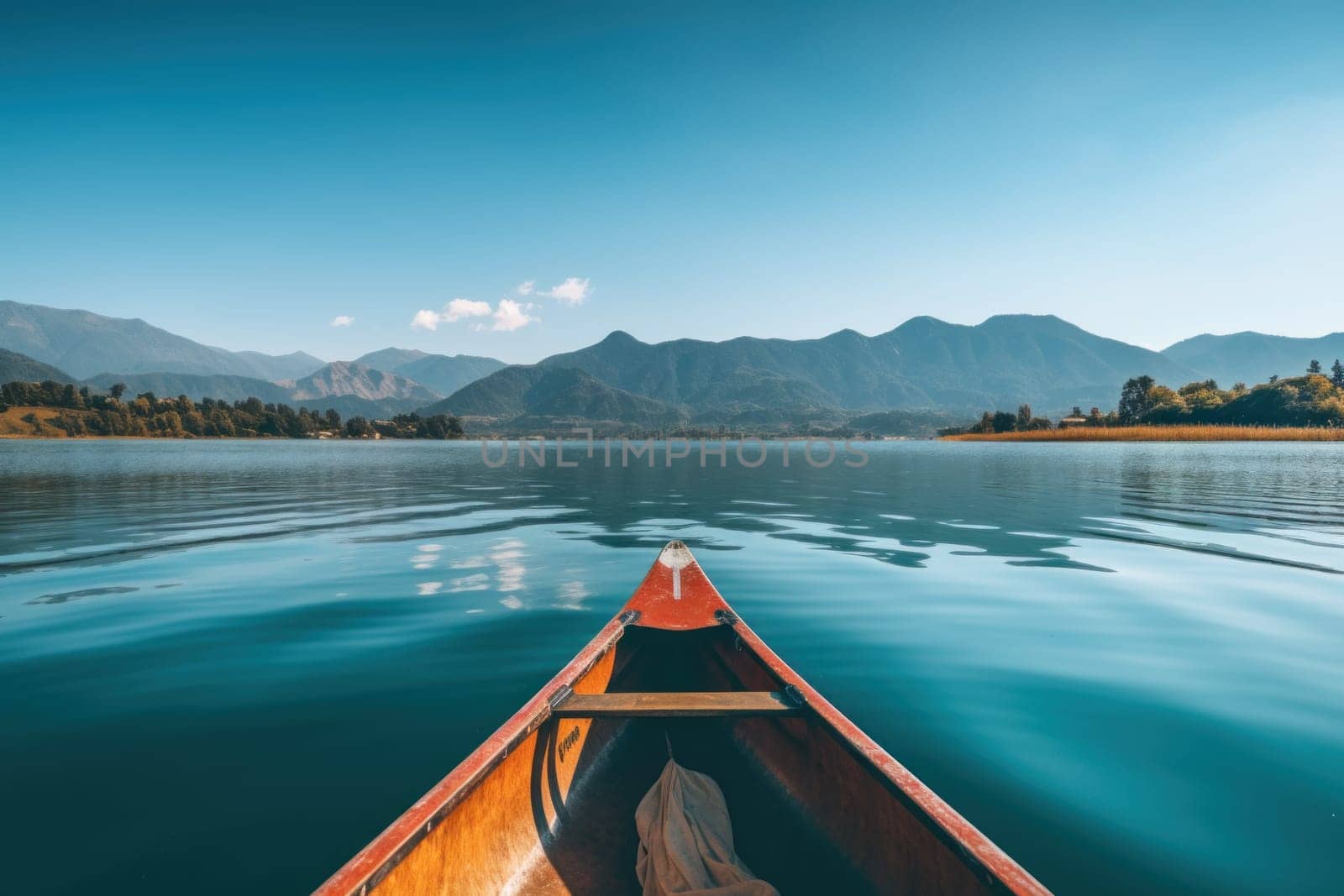 Canoe in the middle of the lake, mountains and clear sky background.