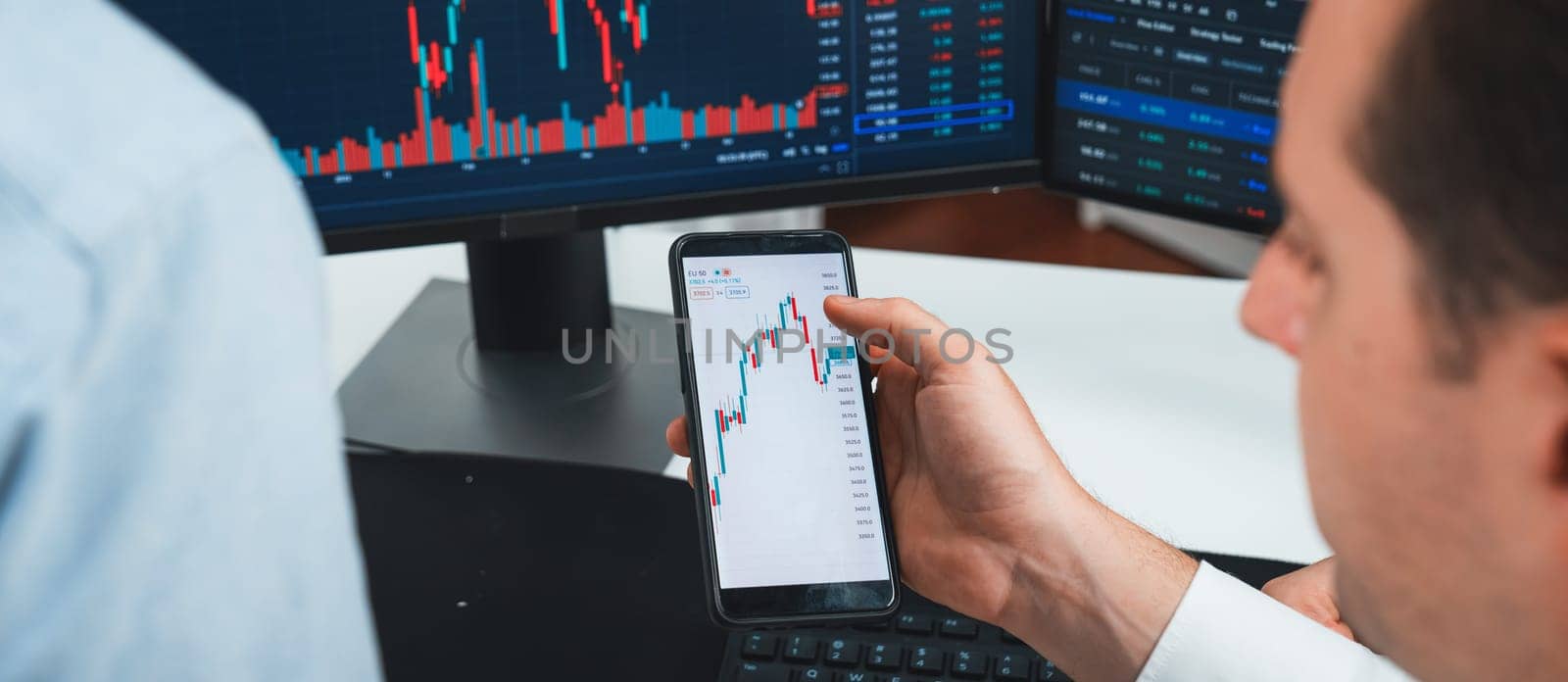 Cropped image of stock traders with hands focusing on dynamic market data analysis, comparing with monitor screen on panorama view. Concept of discussing high profit value rate at workspace. Sellable.