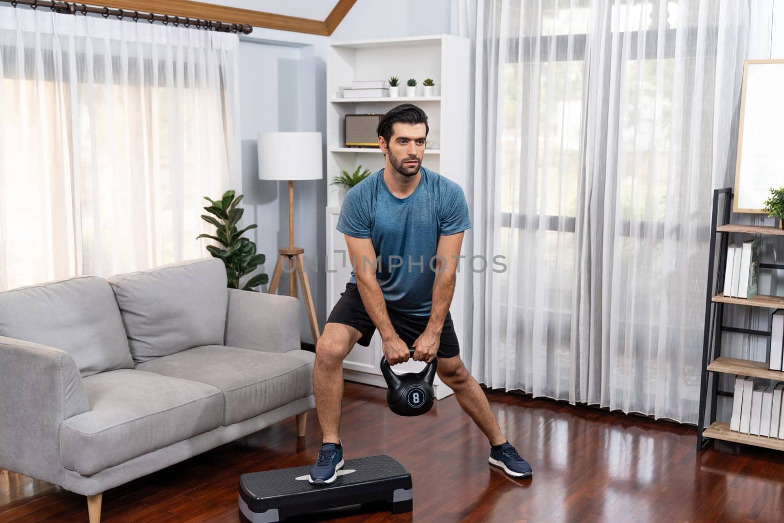 Athletic body and active sporty man doing squat with kettlebell weight for effective targeting muscle gain at gaiety home as concept of healthy fit body home workout lifestyle.